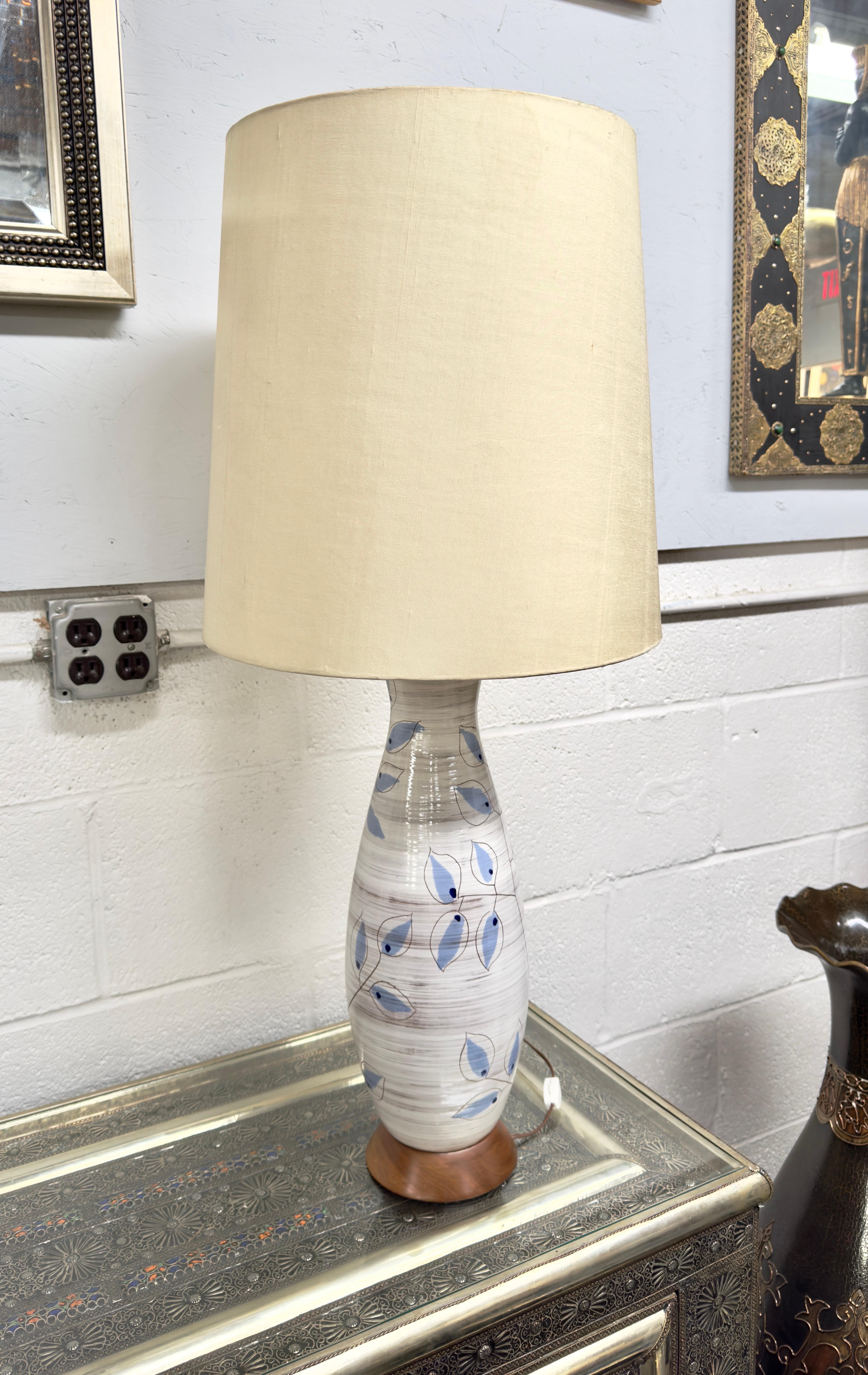 An artisan table lamp crafted by Bitossi of Italy in 1950s. 
Handmade with meticulous care, the botanical design lamp boasts a delicate ceramic construction. The lamp features leaves design , hand-painted in a mesmerizing shade of blue, evoking a