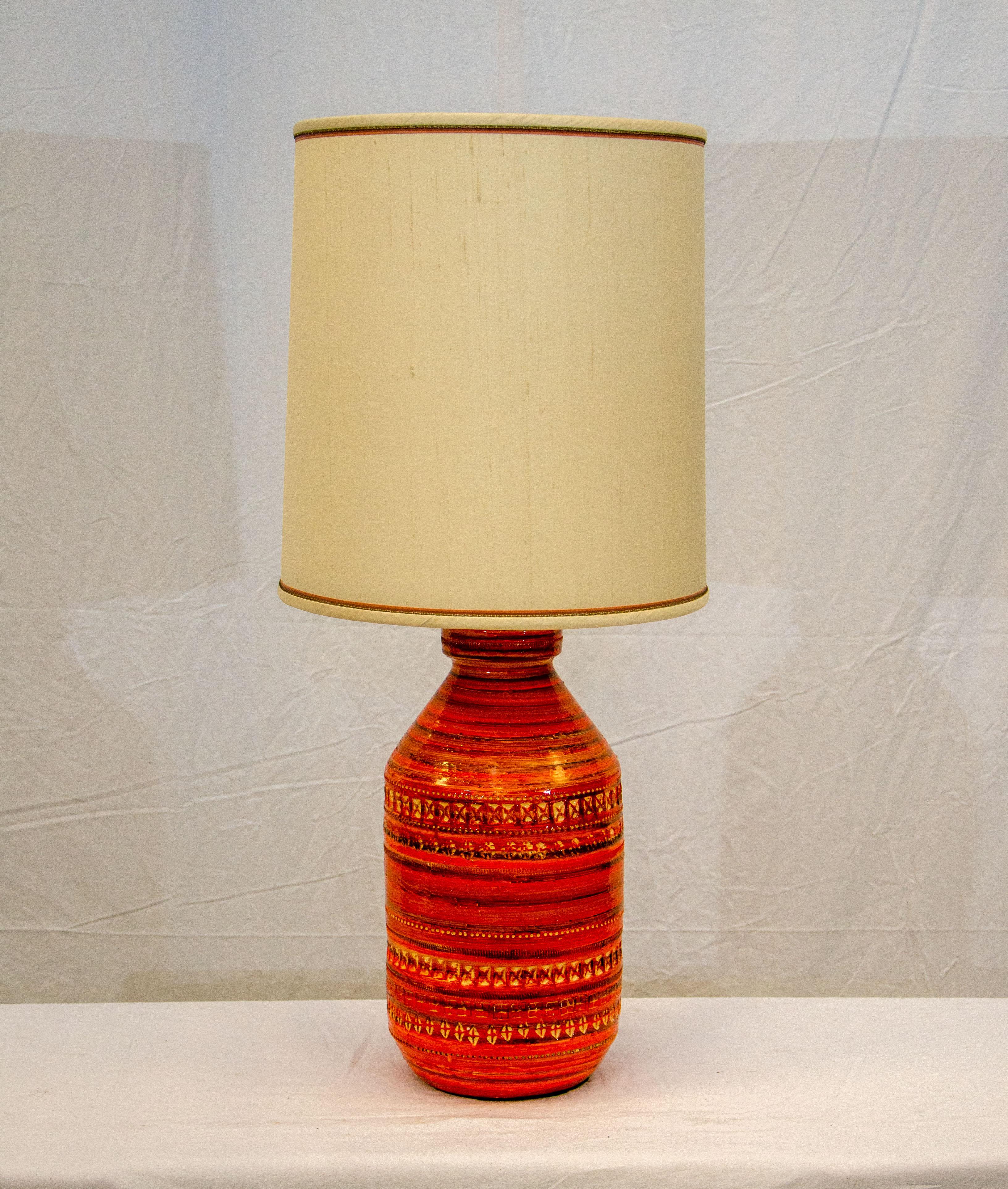 This striking ceramic orange table lamp with an original shade retains the orange & brown small ribbon piping around the top and bottom. The textured shade is 16 1/2