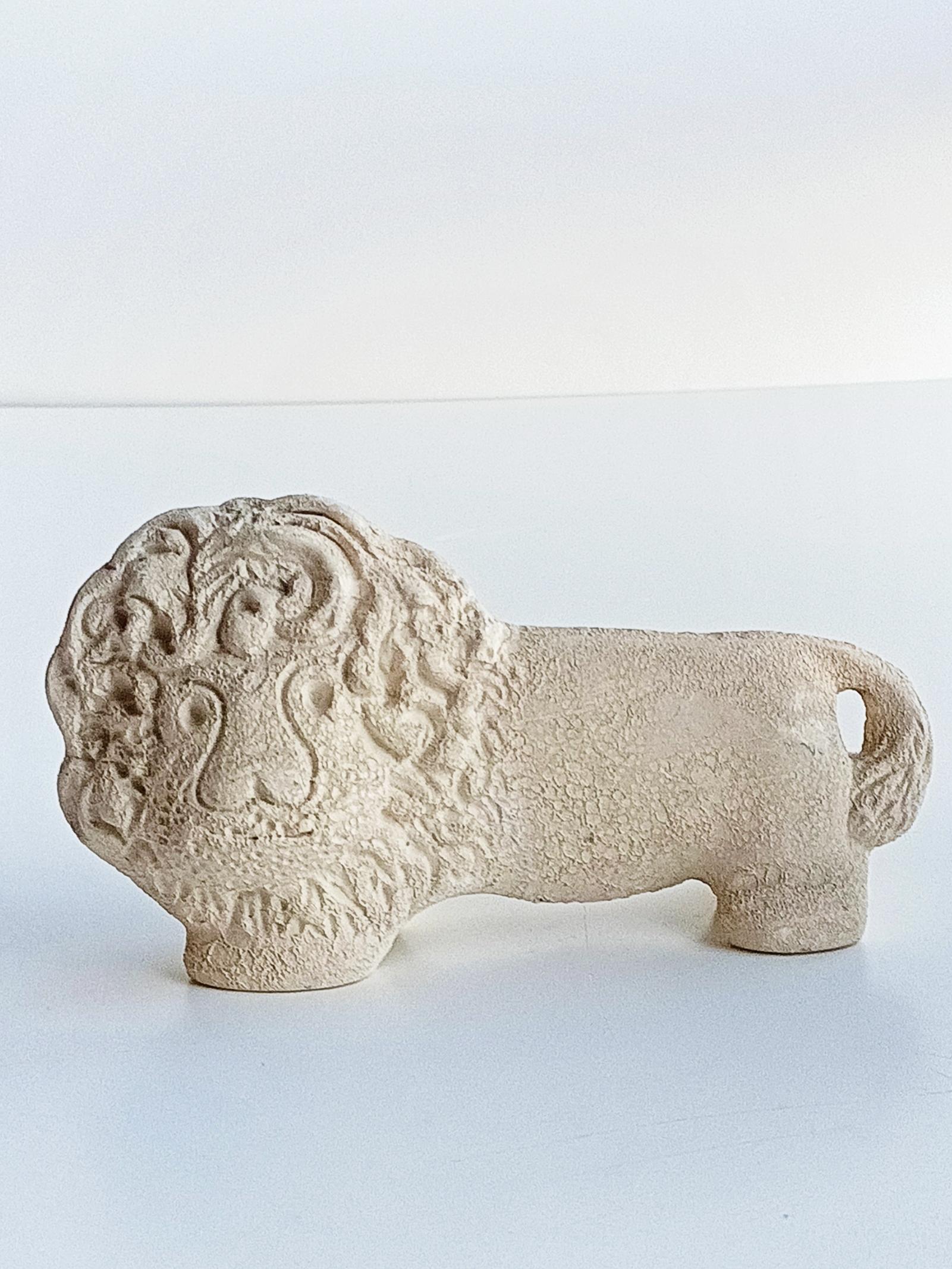 This lion sculpture is indeed a stunning example of Aldo Londi's work for Bitossi Ceramiche. The use of light cream clay with a stone resemblance suggests a sophisticated and classical aesthetic, reminiscent of ancient Roman art and architecture.