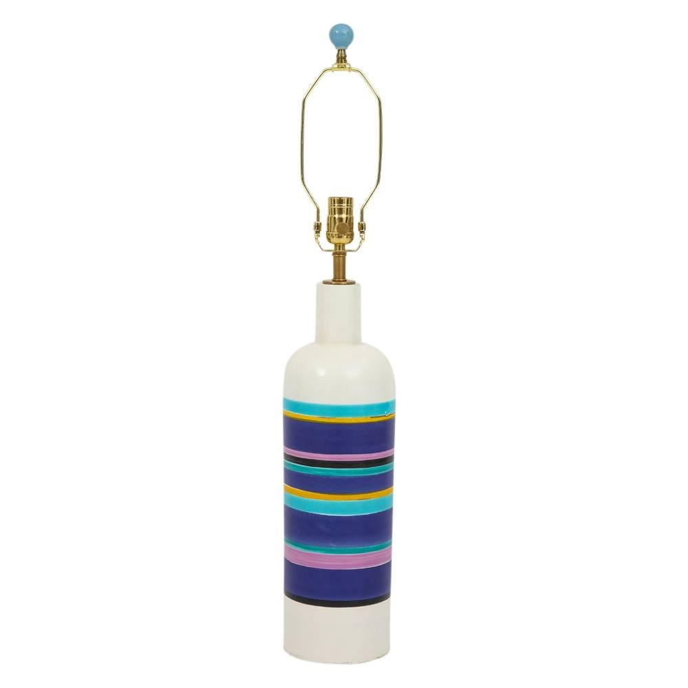 Bitossi lamp, ceramic, white and blue stripes, signed. Bottle shaped form table lamp with horizontal glazed stripes having the following colors: teal, navy, sky blue, magenta, black and yellow stripes over a white glazed body. Rewired with single