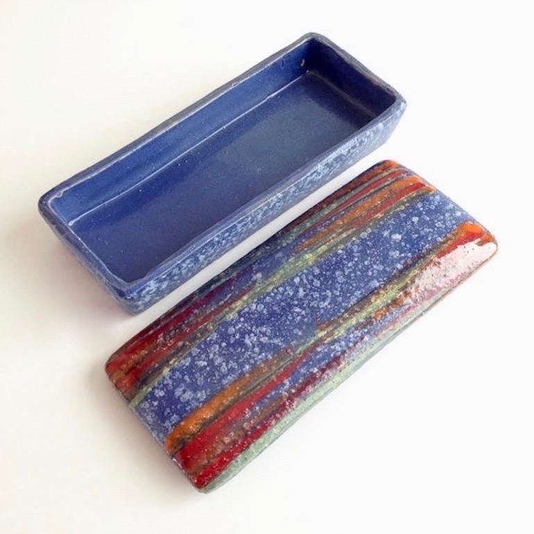Beautiful Italian ceramic box by Bitossi. Blueish purple coloring with orange and red stripes on lid. Good vintage condition.

 