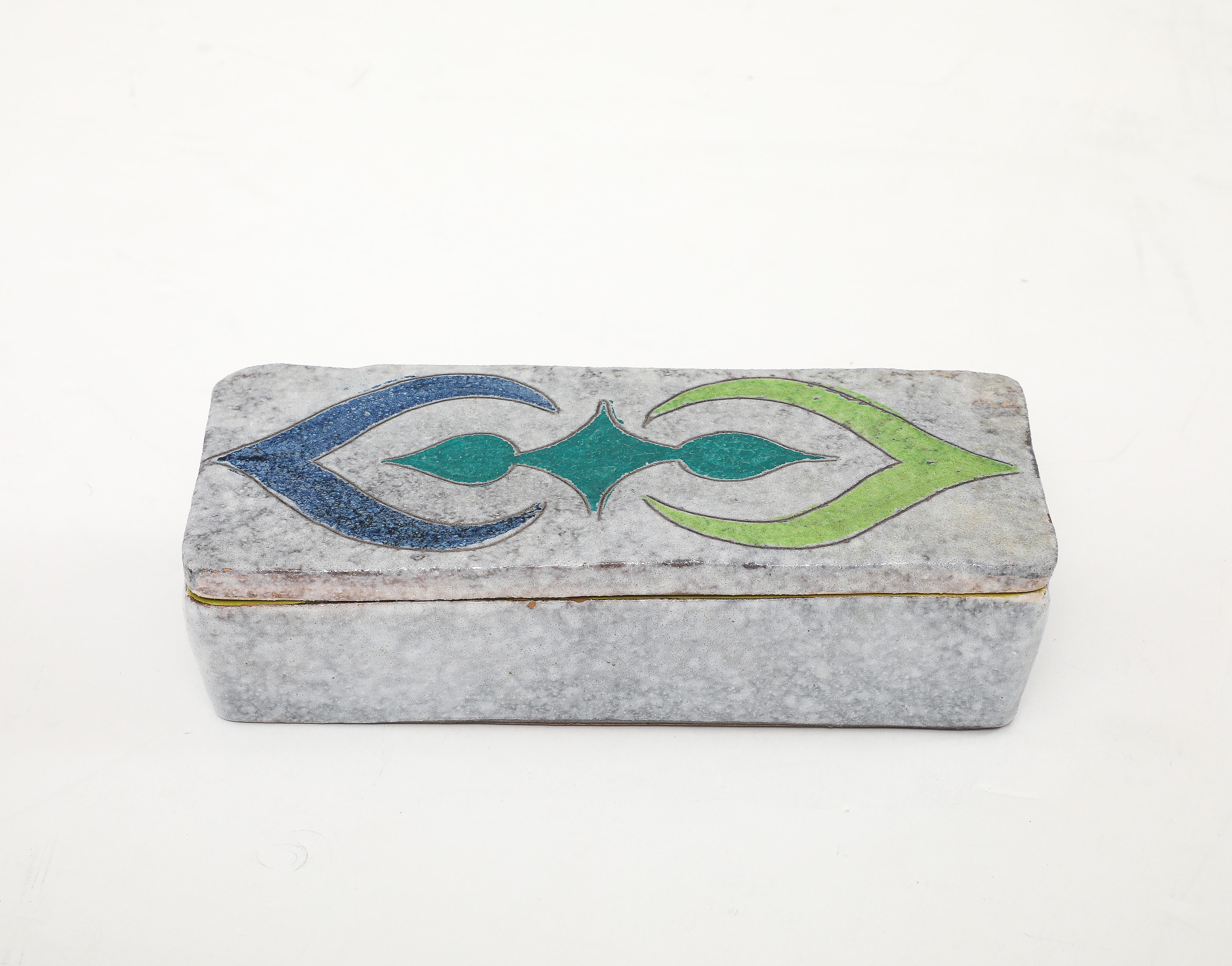 Bone white hand built keepsake box with a blue and green graphic pattern top. Interior of box is glazed in a vibrant green. 