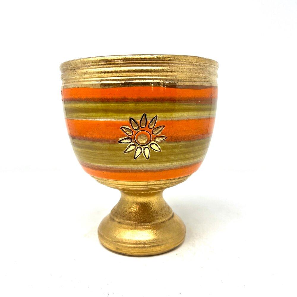 Mid-Century Modern Italian pottery goblet by Aldo Londi for Bitossi. The goblet has bands of orange and gold, and a flower/sunburst gold detail. Marked “Italy” on the underside. In excellent condition.

Measures: Diameter: 6 in / Height: 7 in.