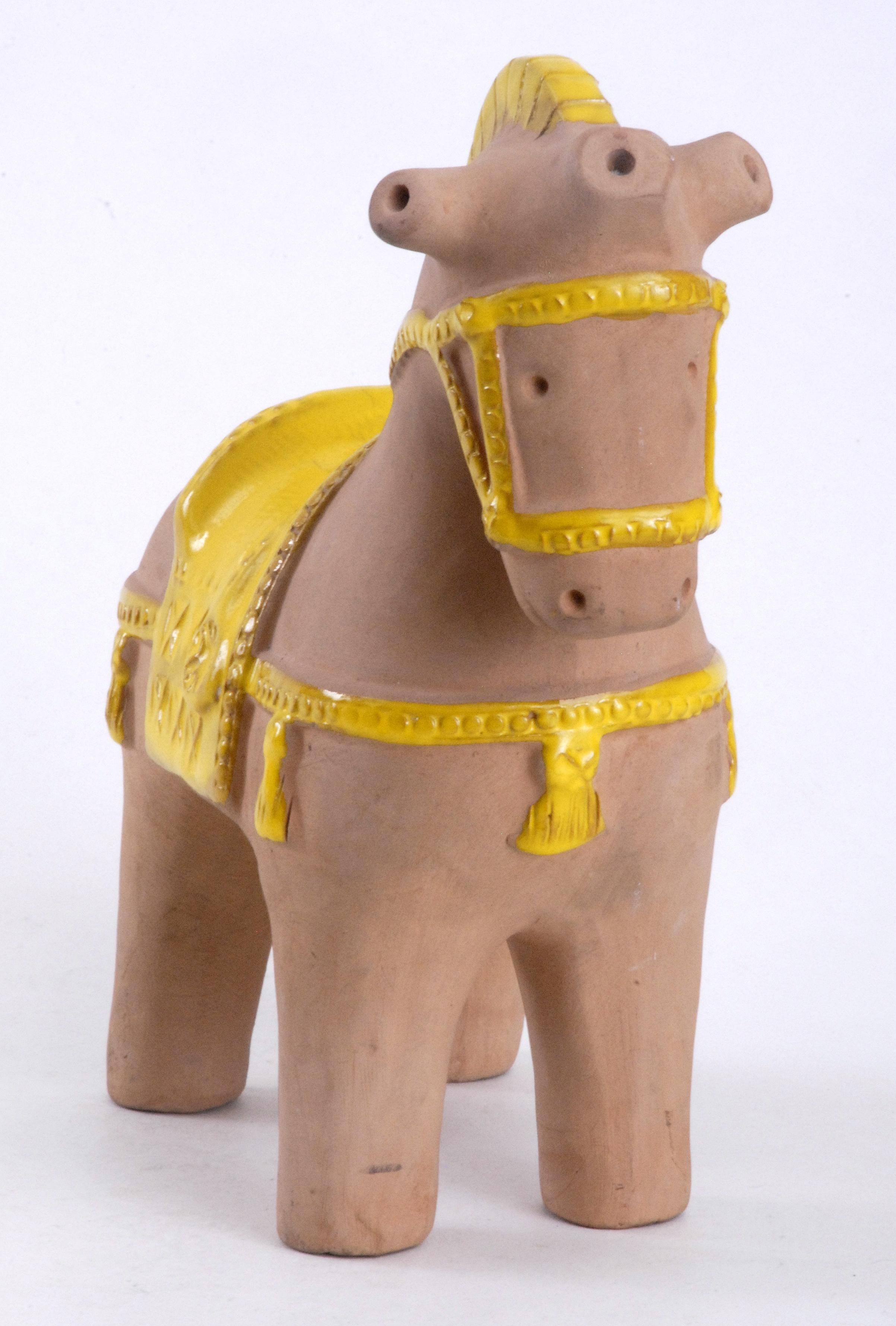 Aldo Londi designed this Chinese styled horse in the 1960s and there is endless variations on the glazes used. All the trappings on this horse have been glazed in a brilliant yellow over the unglazed natural clay. There are some minor marks on the