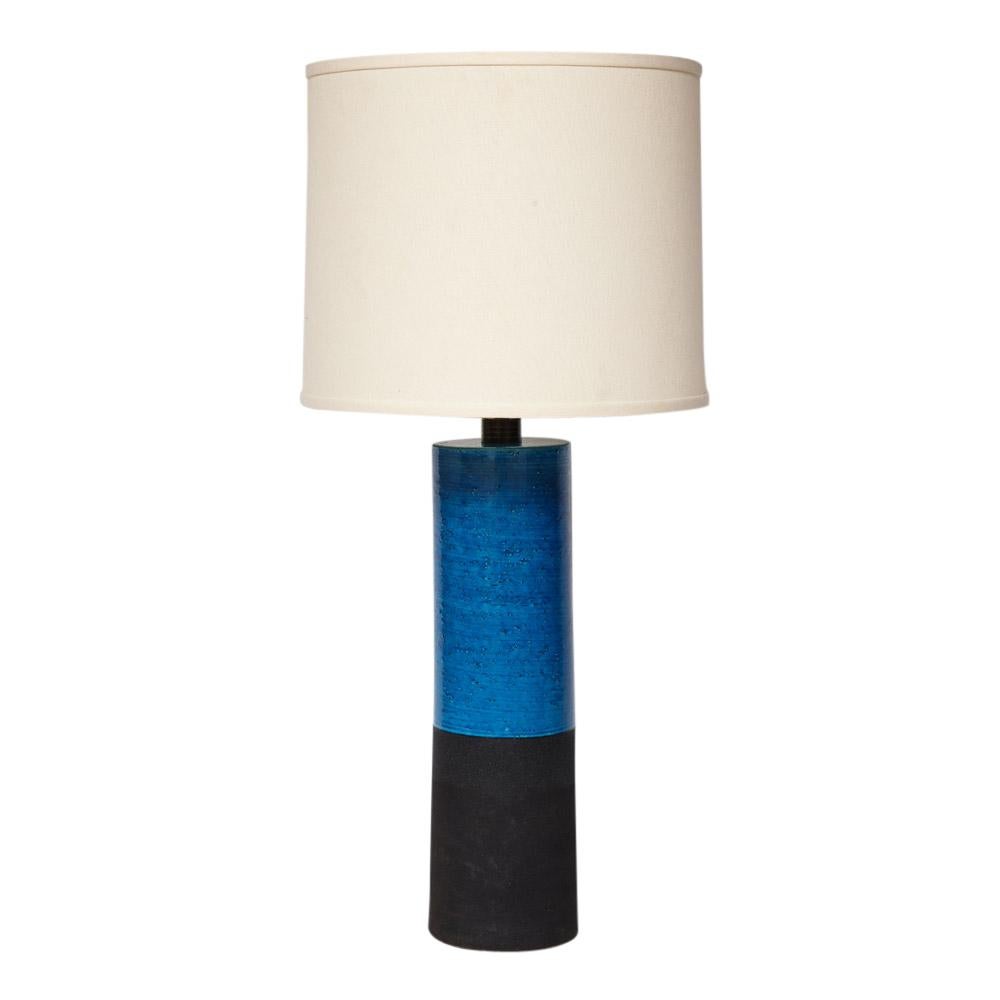 Bitossi lamp, ceramic, blue and black. Tall ceramic cylinder lamp glazed in semi-gloss blue and contrasted with a textured matte black. 
Measurements:
The ceramic body measures 18 inches. 
The measurement from the base to the bottom of the sockets