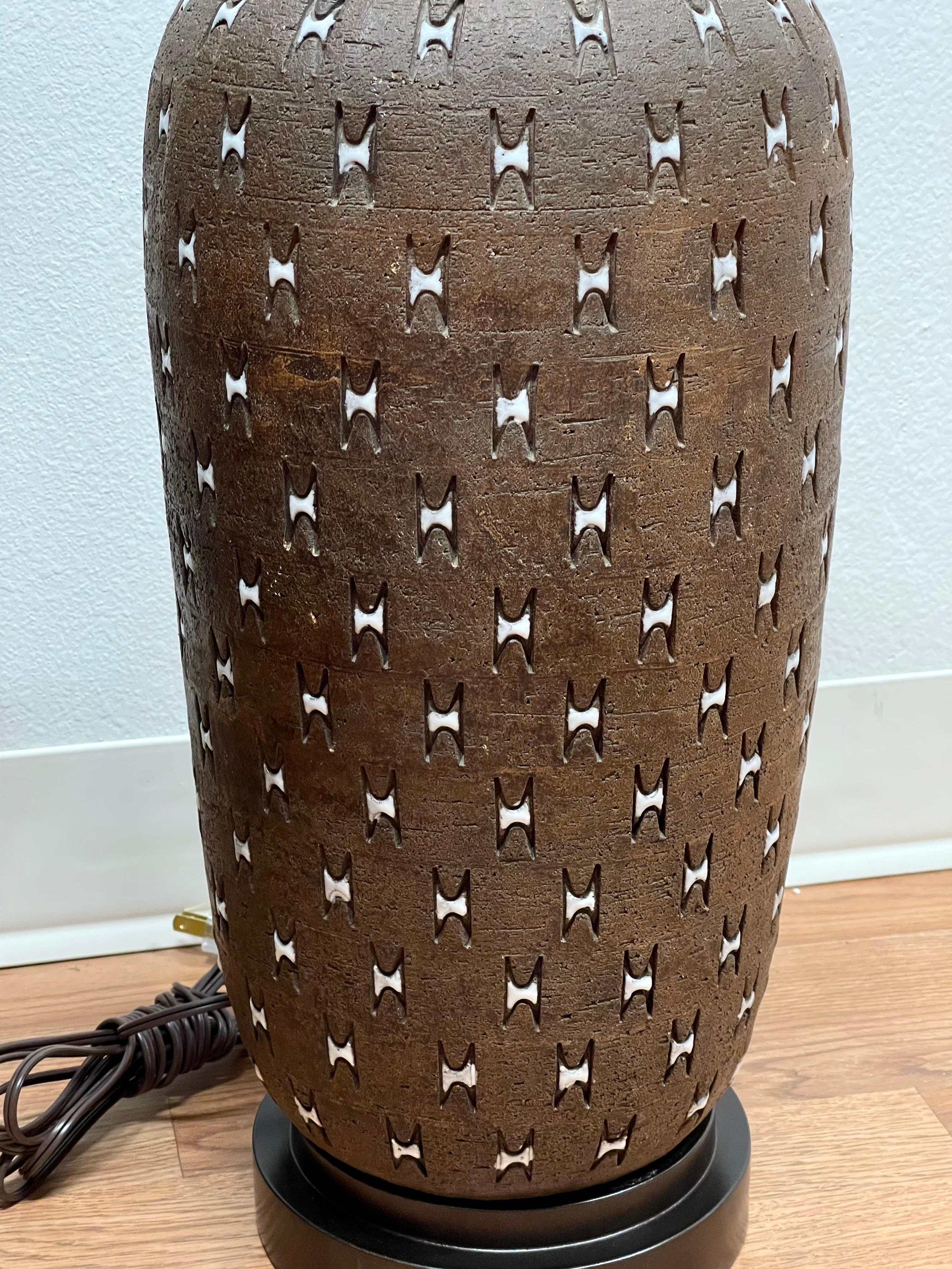 A large pottery lamp by Bitossi. Great pattern and coloring. Signed on the base made in Italy. The base we had remade and painted brown while the wiring is new as well. The pottery has some inherent glaze flaws and imperfections. Pottery itself is 1