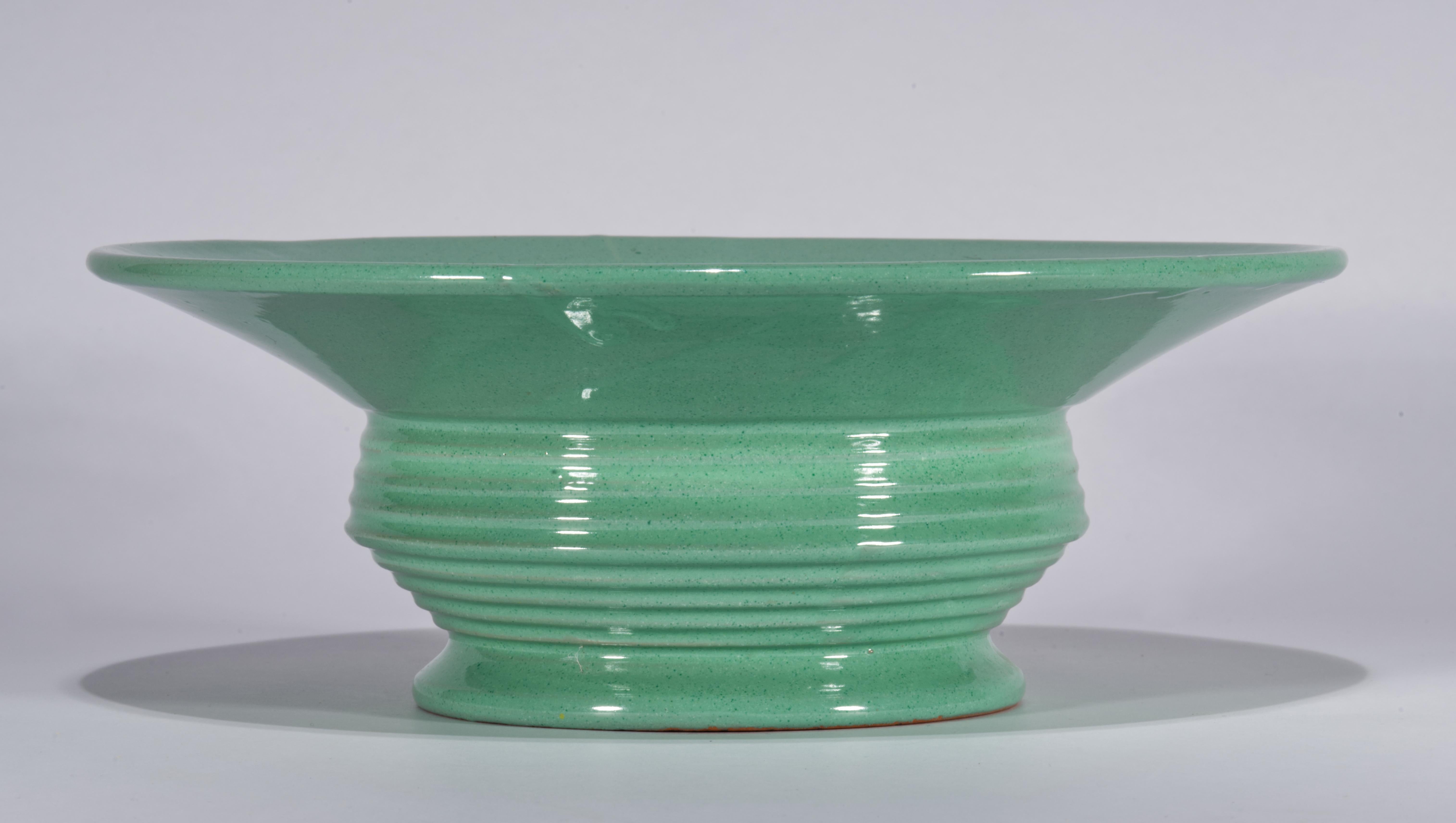 Modernistische Majolika-Schüsselvase oder Tafelaufsatz mit komplexer skulpturaler Form mit gestuftem Körper, ausgestelltem rundem Fuß und markantem abgewinkeltem Rand; die minimale Form des Stücks wird durch die monochromatische blaugrüne Glasur