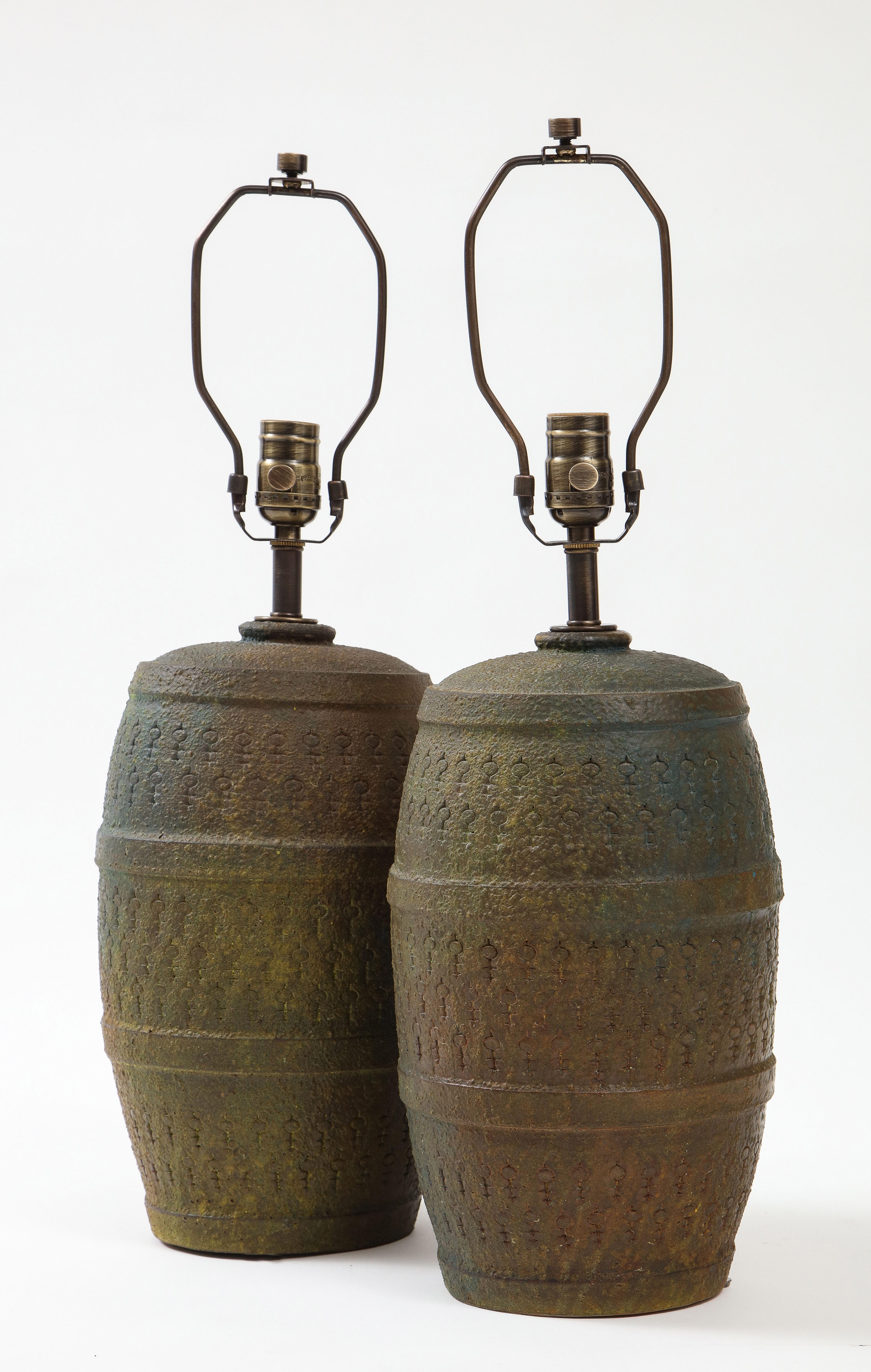 Pair of Italian Mid-Century Modern matte dark green/loden glazed barrel form ceramic lamps. Lamps feature a hand incised all over stylized key pattern. Signed. Rewired for use in the USA using dark brown silk cord and new bronze sockets, 100W max