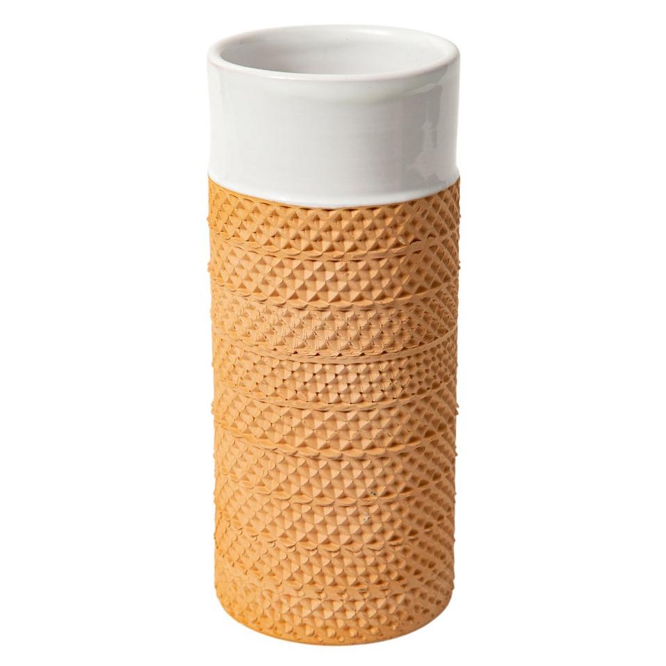 Bitossi for Raymor ceramic vase, white and impressed terracotta, signed. Small to medium scale cylinder vase with glazed white neck and an unglazed terracotta honeycomb patterned body. Signed on the underside with partial Raymor label.
   