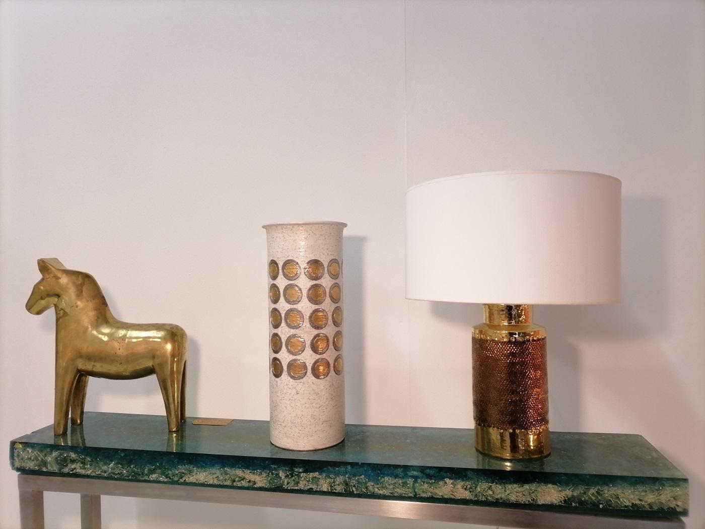 Bitossi stoneware Chamotte gold table lamp, Italy, 1970.

 Bitossi table lamp

Decor with gold and copper relief 

Measures without shade
Height 31cm, diameter 14cm

Shade included, height 22cm, diameter 35cm

Good conditions.