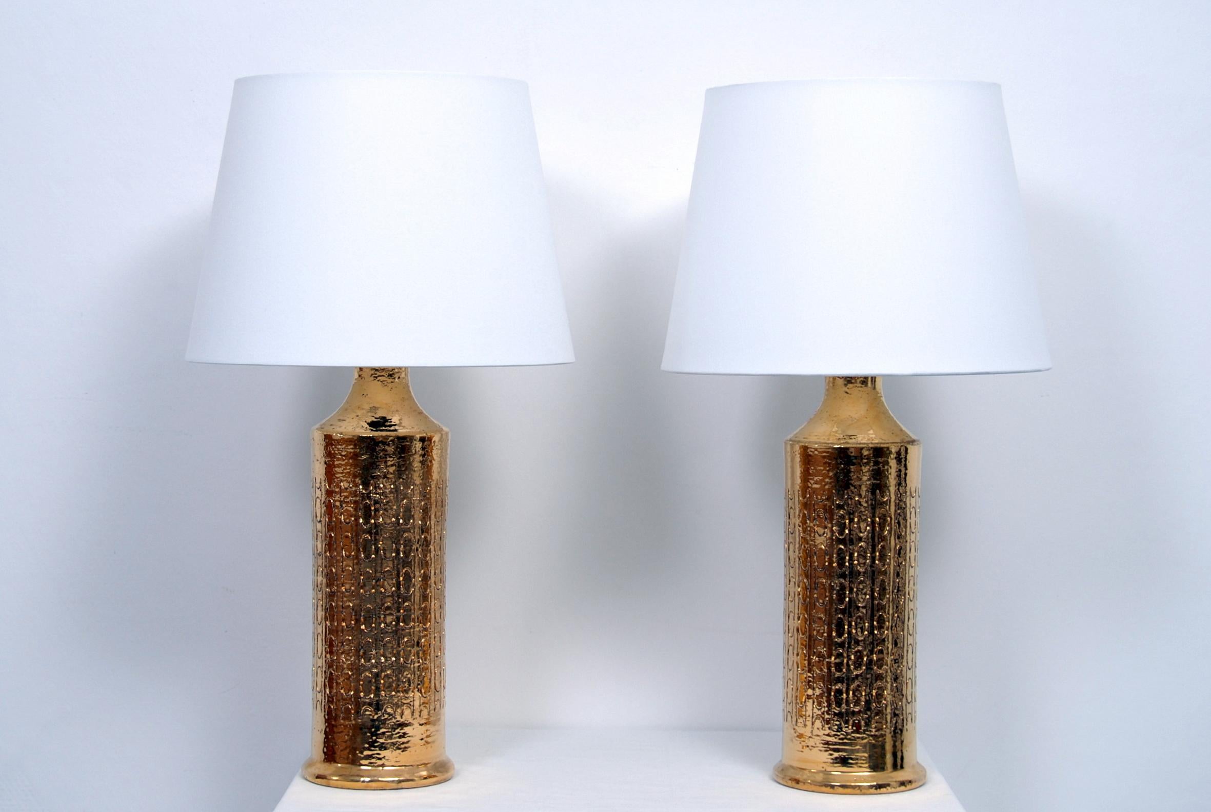 A pair of Bitossi table lamps with hand incised decorative bands with a striking gold glaze. Made in Italy for the Scandinavian market. Lamps have been rewired. Ceramic body measures 35 cm. Shades not included.

  