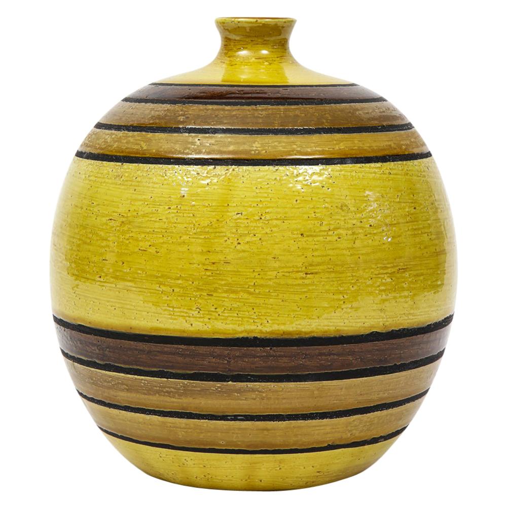 Bitossi vase, ceramic, chartreuse green, earth tones, stripes, signed. Medium scale chunky spherical form ball vase glazed in chartreuse green and decorated with 3 bands of dark earth tones at the neck and base. Signed with original paper import