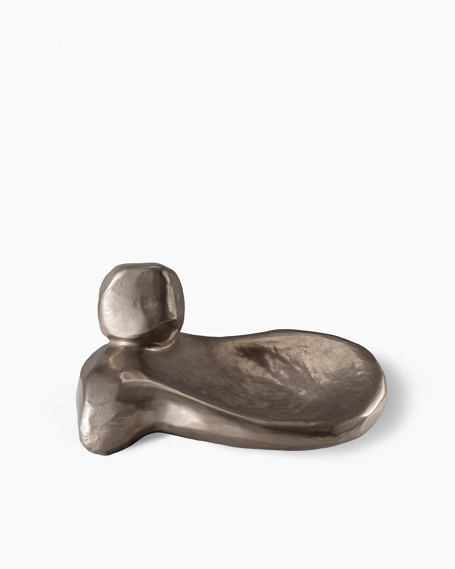 Hand-modeled sculpture, composed of two elements in white clay. The still-fresh surface is hand-smoothed. White glaze applied in the second firing and platinum glaze in the third firing.

Presented in 2022, the collection consists of five
