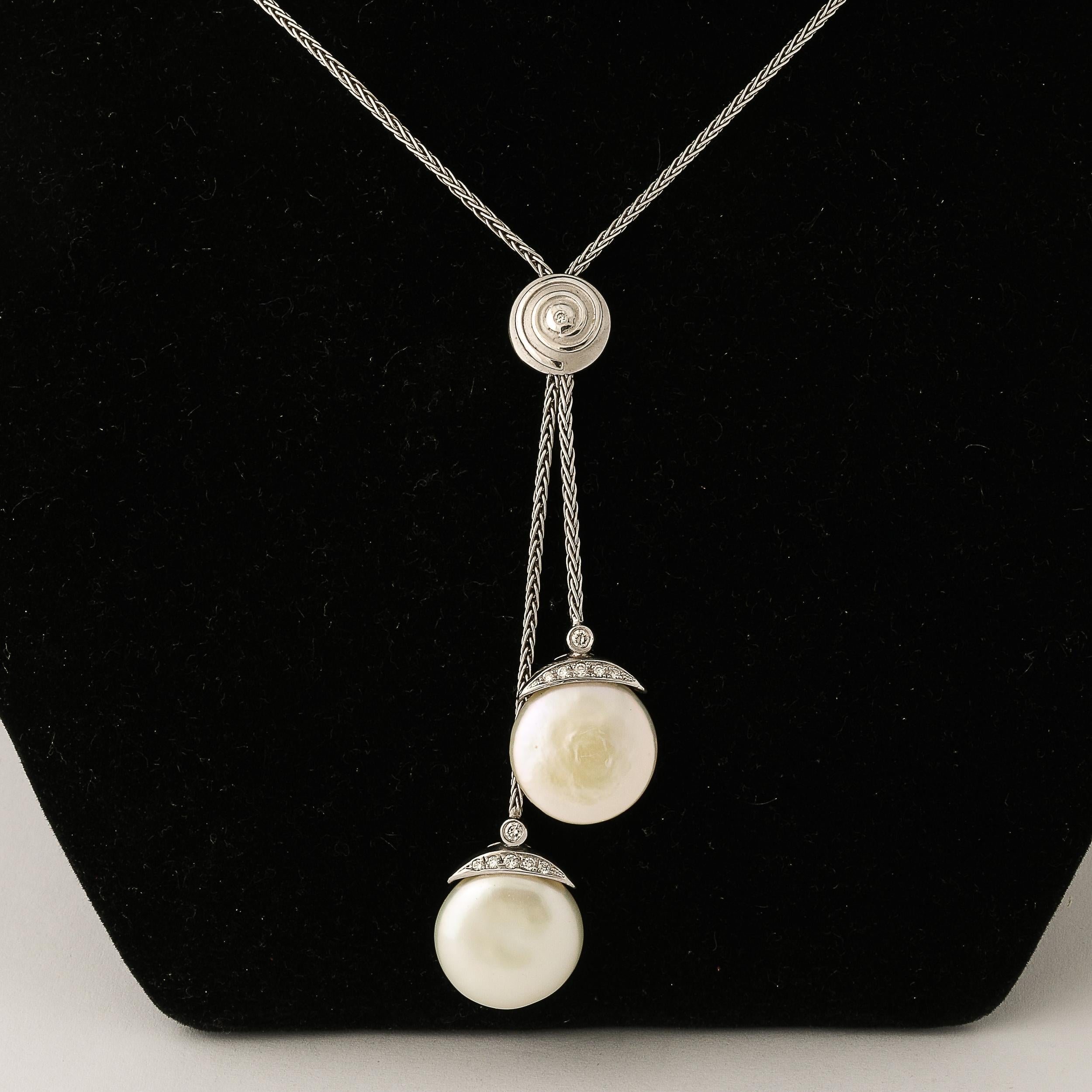 Questa sofisticata collana Tie, della Collection'S Biwa di Yvel, offre una nuova prospettiva ai classici gioielli di perle. Due lucenti perle tonde e piatte da 14 mm sono sospese con grazia, aggiungendo un senso dinamico di movimento. Ogni perla è