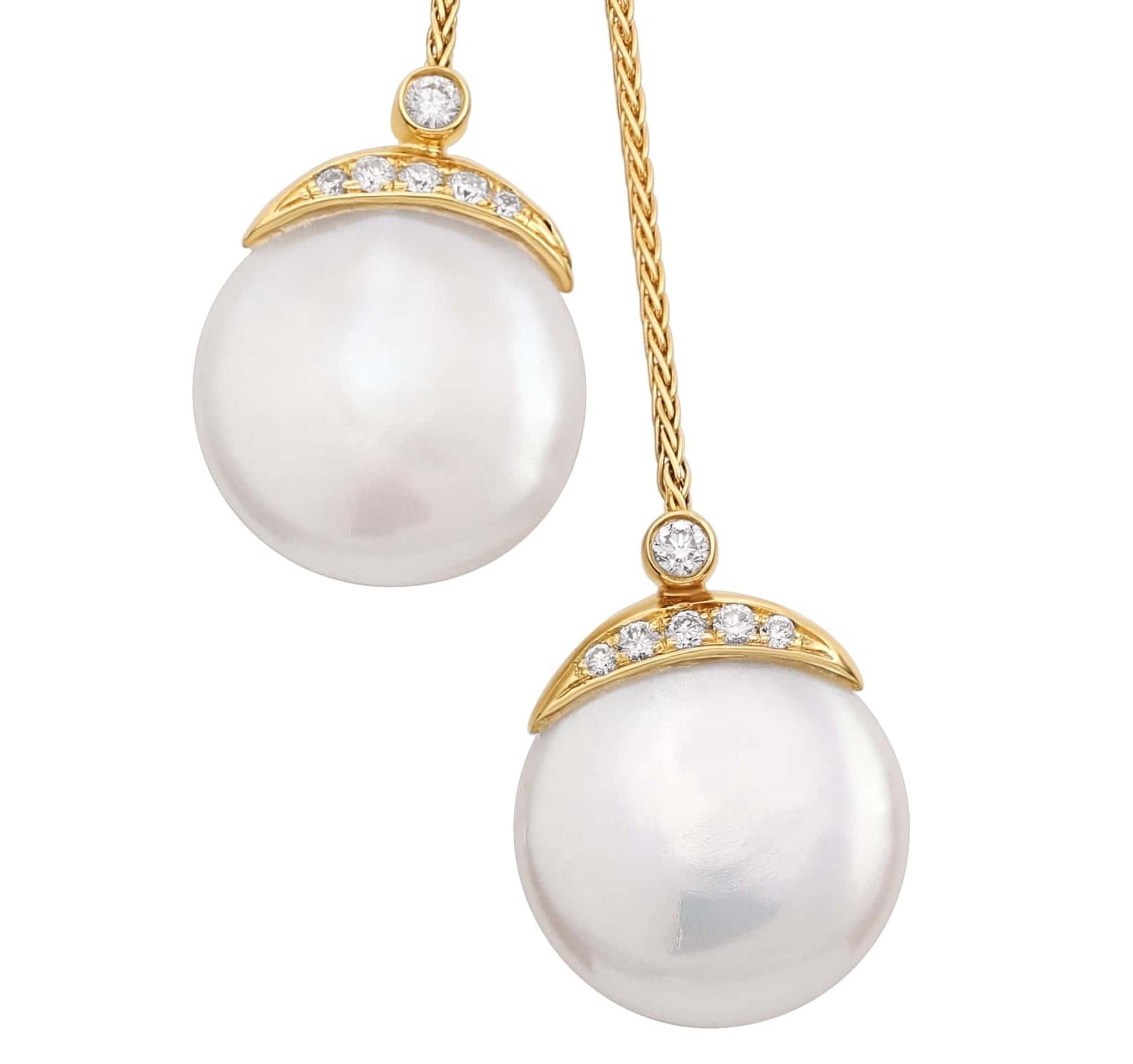 This 18K yellow gold necklace from the Biwa Collection is a harmonious blend of tradition and contemporary design. It features two 14 mm. round flat freshwater coin pearls, each adorned with a sparkling halo of 0.24 ct. diamonds. The pearls dangle