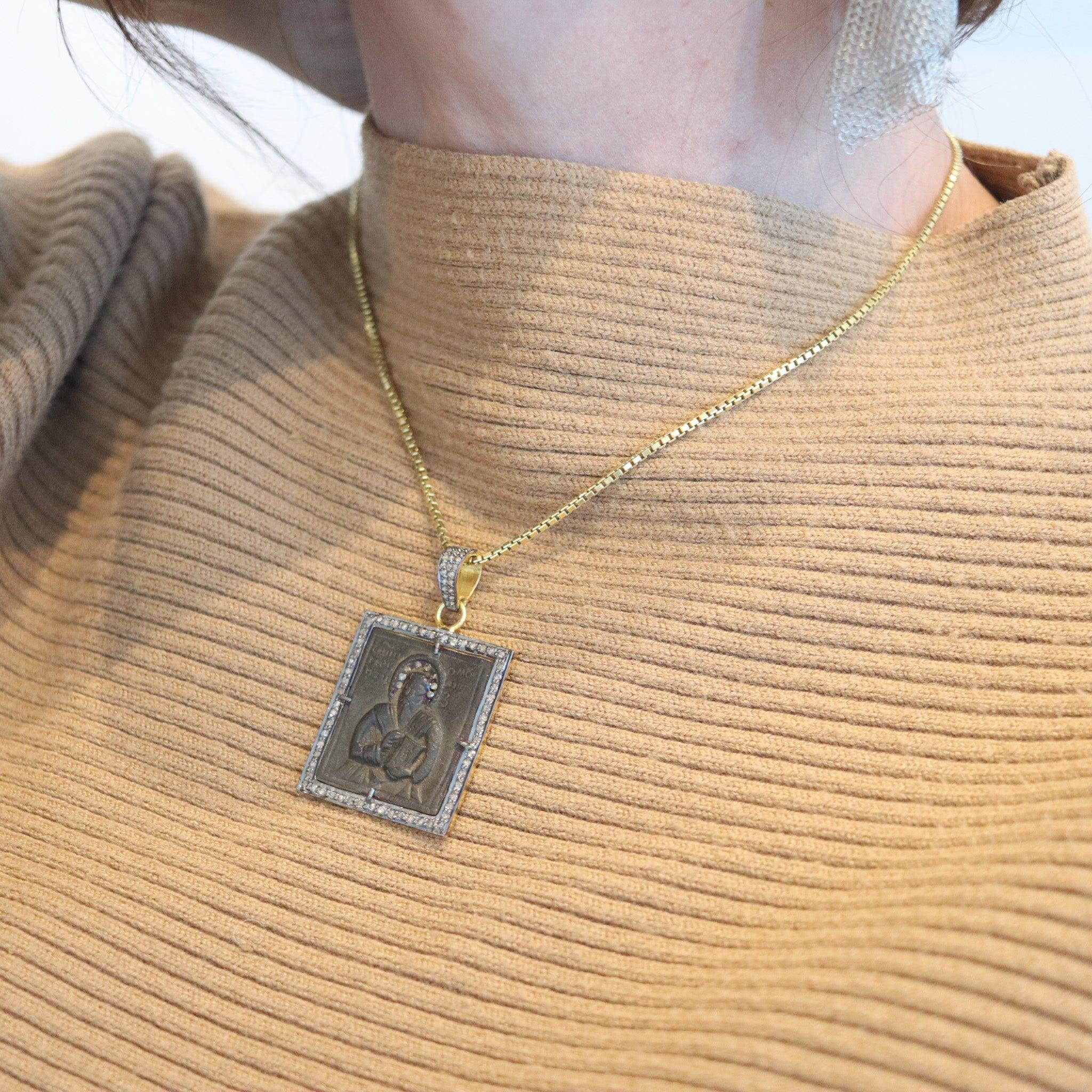 Eine orthodoxe Ikonenmedaille aus dem 17. Jahrhundert.

Das Herzstück dieses Anhängers ist eine antike, quadratische byzantinisch-orthodoxe Ikonenmedaille aus dem späten 17. Diese antike Medaille wurde in der Stadt Novgorod in Russland gefunden und