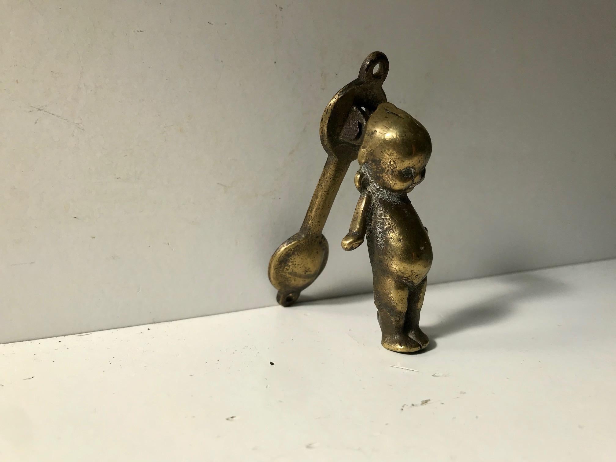 Small yet detailed and well-patinated door knocker in brass. Manufactured in Europe, probably, England during the early to mid-19th century. It has a charming patina and ware indicative of being handled and receptively touched and used for well over
