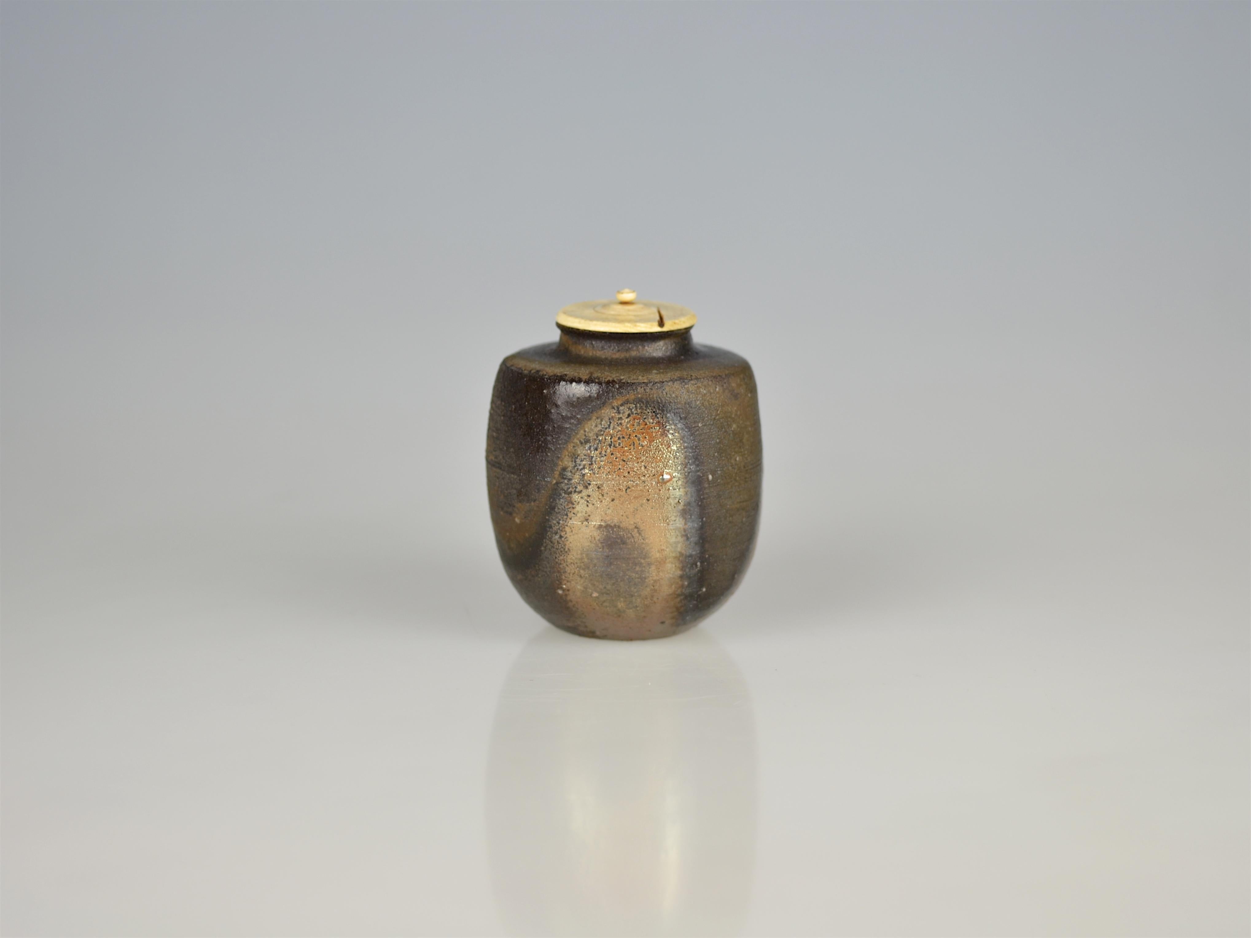 This Bizen chaire is truly a once-in-a-life-time item. Thrown with crisp contour on a potter's wheel, the tea caddy has got a unique ash glazing afterwards. Between a rough brown texture, two parts of the vessel's exterior give the sight free on the