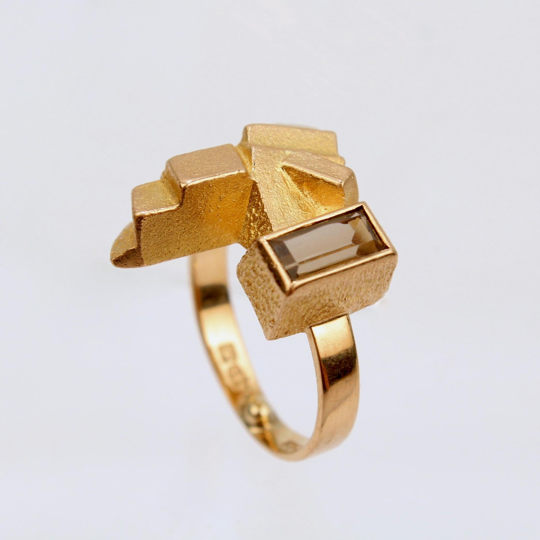 A very fine modernist Björn Weckström 14k gold and smoky quartz ring.

In 14k yellow gold with a layered cubist surface and with a bezel set smoky quartz emerald cut gemstone.

Weckström's work as designer and art director for Lapponia vaulted the