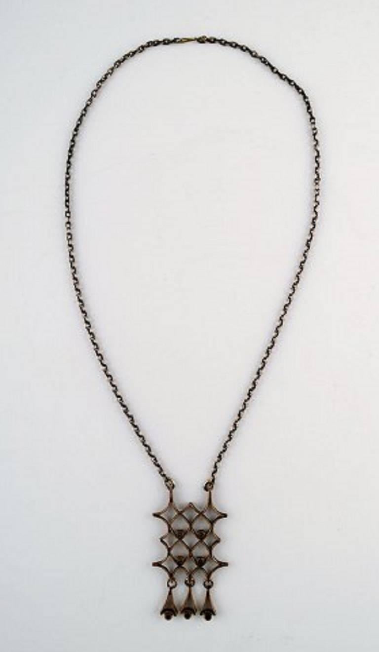 Pentti Sarpaneva, Finland. Vintage modernist large necklace in bronze, hand made.
1960s.
Total lenghts 62 cm. Pendant 5 cm. x 7 cm.
