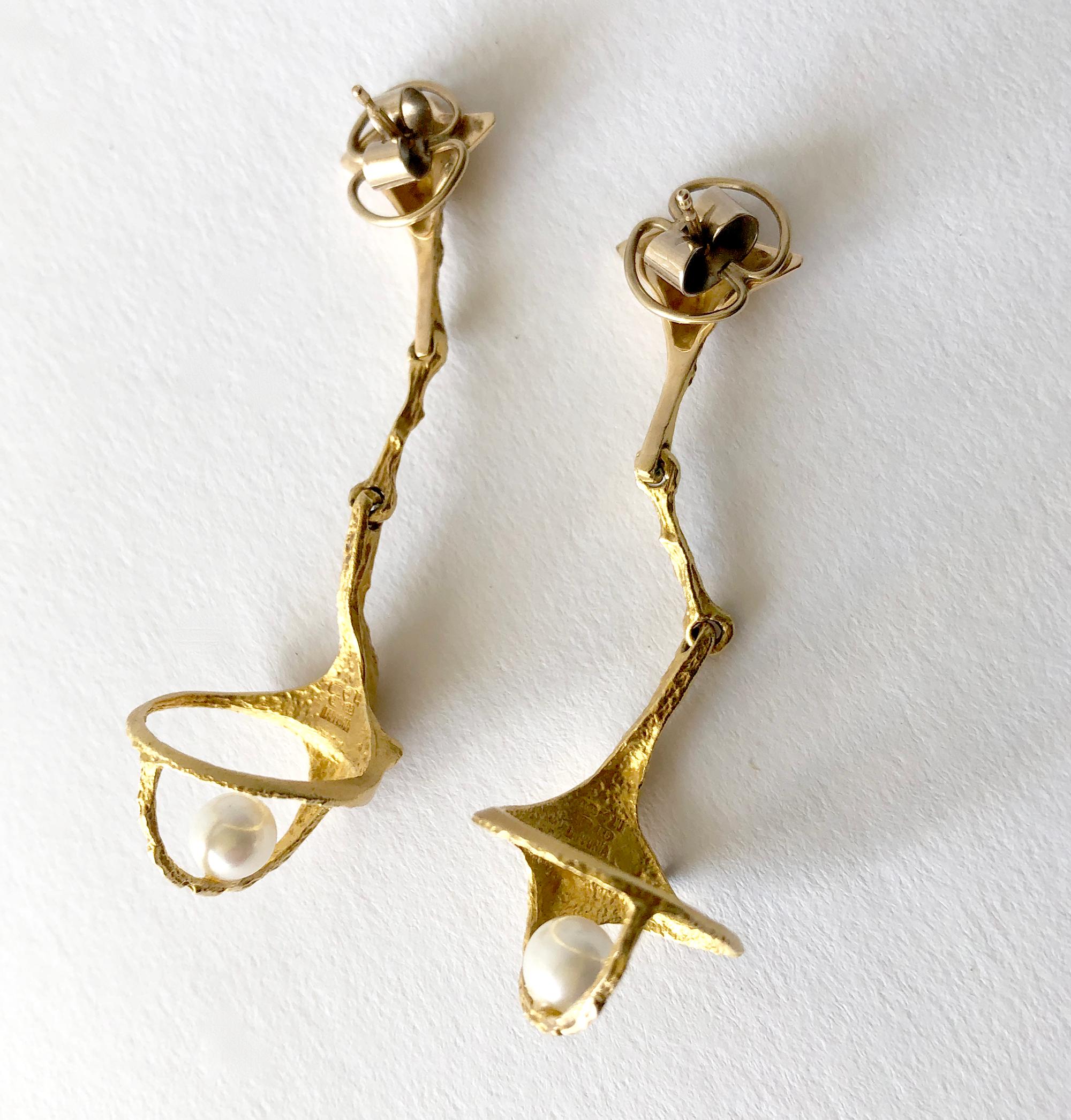 Pearl and 14K gold modernist earrings created by Finnish Master sculptor and jeweler, Bjorn Weckstrom.  Earrings have a hinged stem and basket which holds a pearl.  They measure 2 3/8