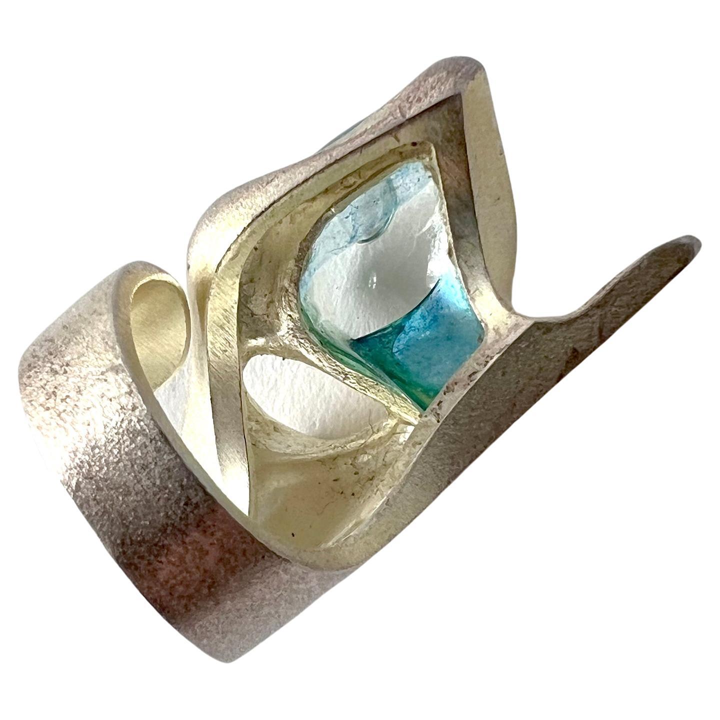 Bjorn Weckstrom for Lapponia sterling silver with blue acrylic 'stone' entitled Kohoutek.  Ring was first designed in 1973, this is a reissue created in the year 2000.  Signed with Finnish Hallmarks, Lapponia, BW, Y8 (2000) and is a size 7.25 - 7.5.