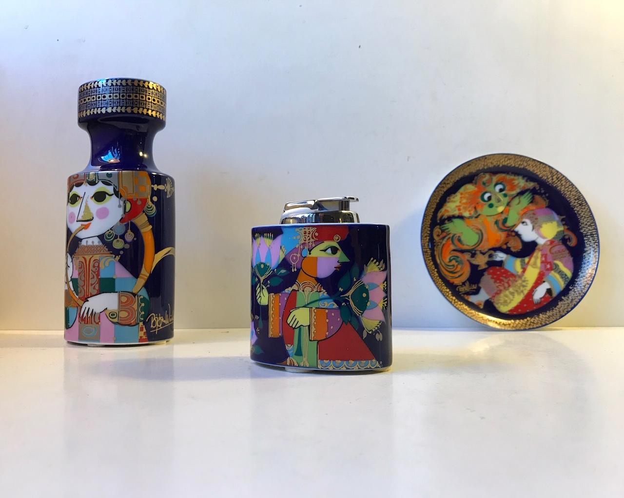 Wiinblad Studio Line set consisting of ashtray/dish, candlestick and table lighter. Colorful and characteristic Wiinblad fantasy figurines. Manufactured by Rosenthal in Germany during the 1970s. The lighter itself is from Ronson and has not been