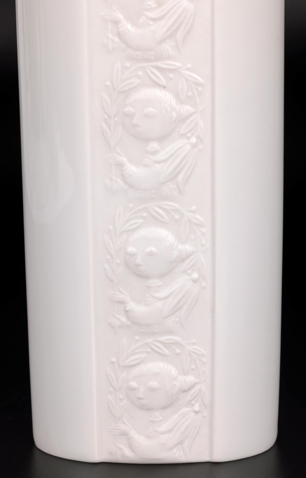 Ce vase en porcelaine de Rosenthal du milieu du siècle dernier, finement réalisé et élégant, est décoré d'un personnage tenant une haute tige florale, conçu par le célèbre artiste danois Bjorn Wiinblad (1918-2006). Ce vase en porcelaine blanche,