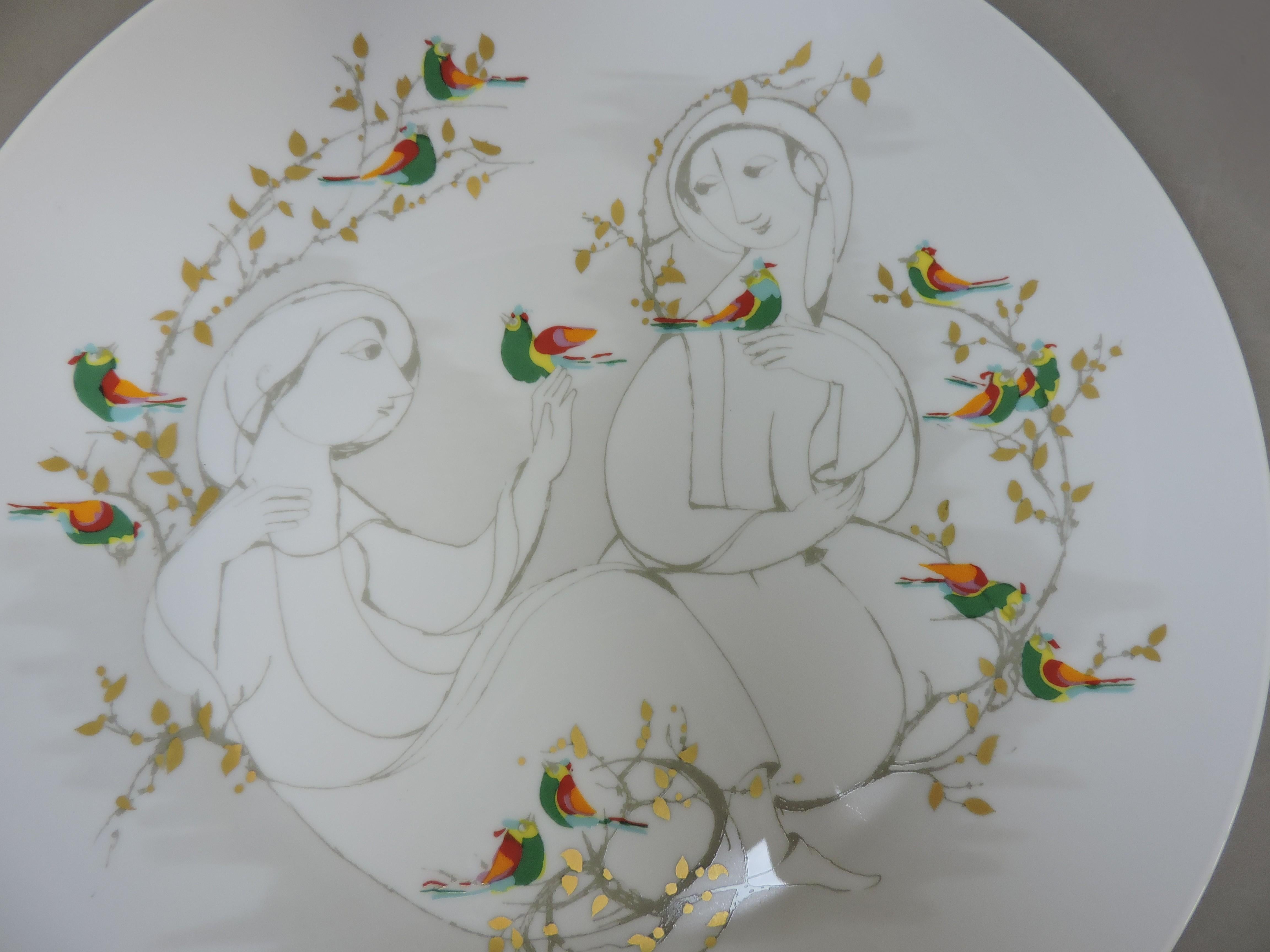 Beautiful and large 13 inch charger designed by Born Wiinblad for Rosenthal and manufactured in Germany. This white porcelain plate has lovely imagery with gold and colorful accents. There are two holes on the back for hanging.