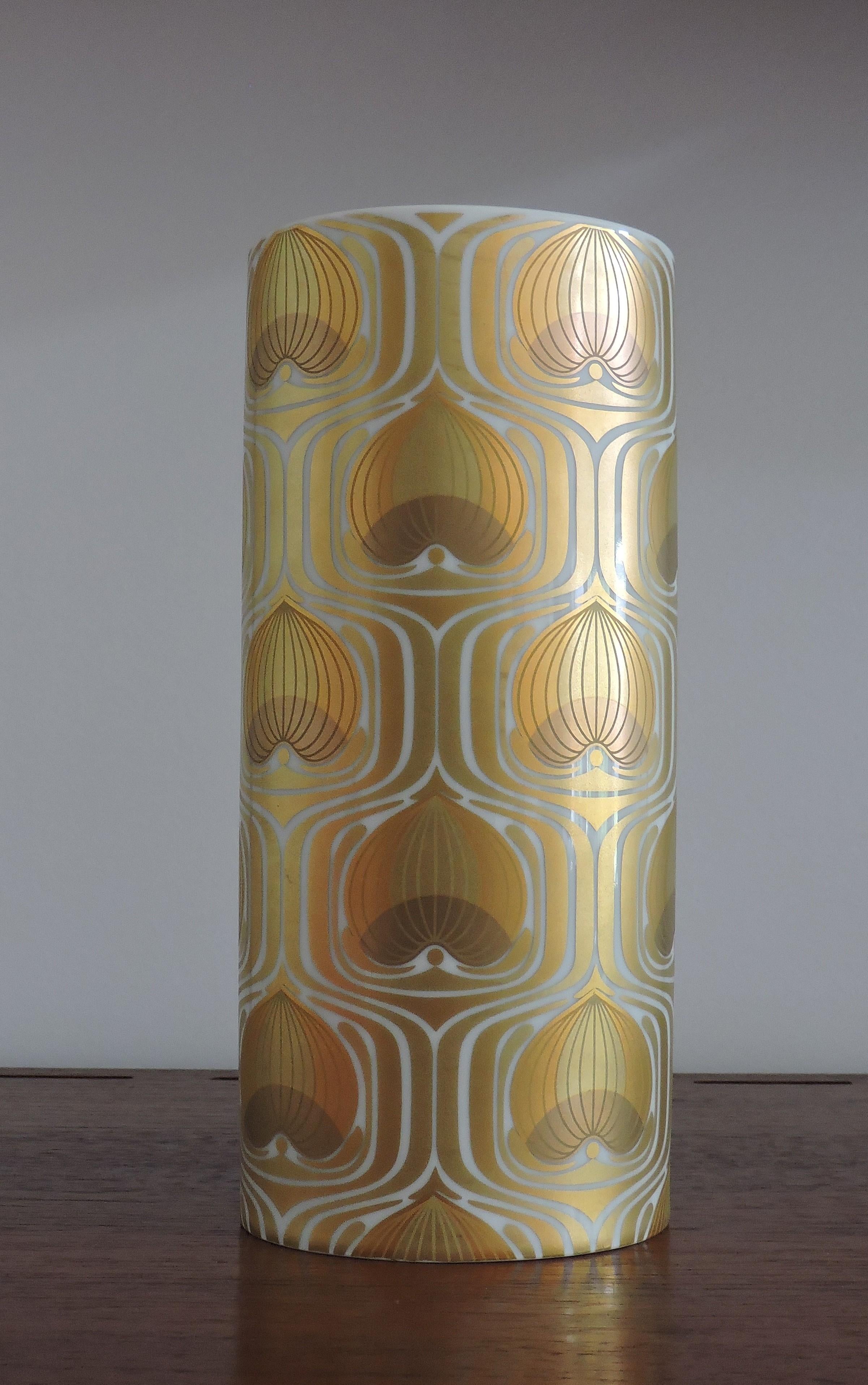 Beautiful and large 9 1/2 inch tall vase designed by Born Wiinblad for Rosenthal and manufactured in Germany. This cylindrical vase has an intricate gold pattern on white porcelain.