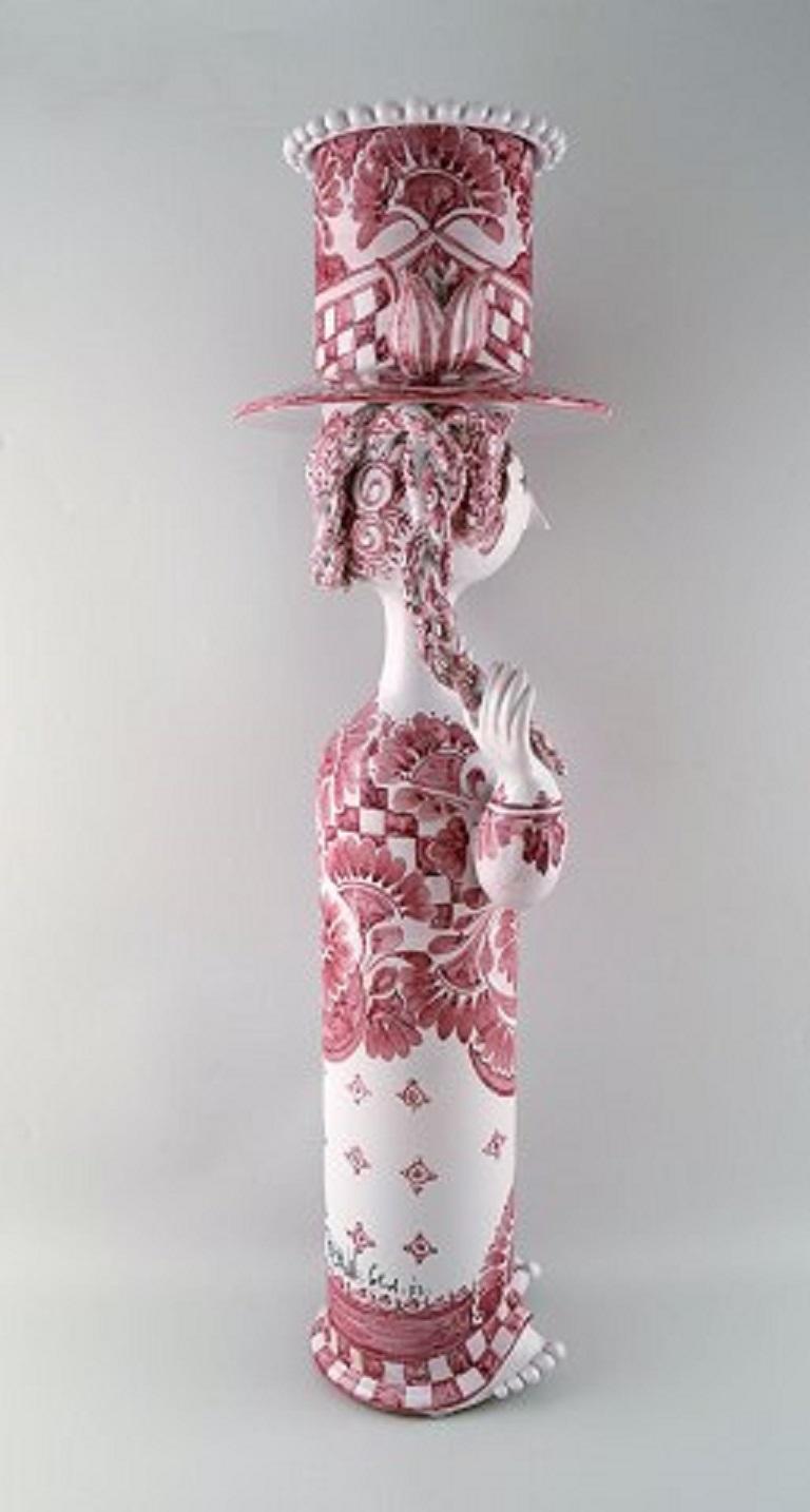 Bjorn Wiinblad: Very rare and monumental female figure of stoneware. Top with flower pot in the shape of a hat.
Decorated with red-colored motifs on light gray base, braids with dark red glaze.
Measures: 76 x 26 cm.
In perfect condition.
Signed,