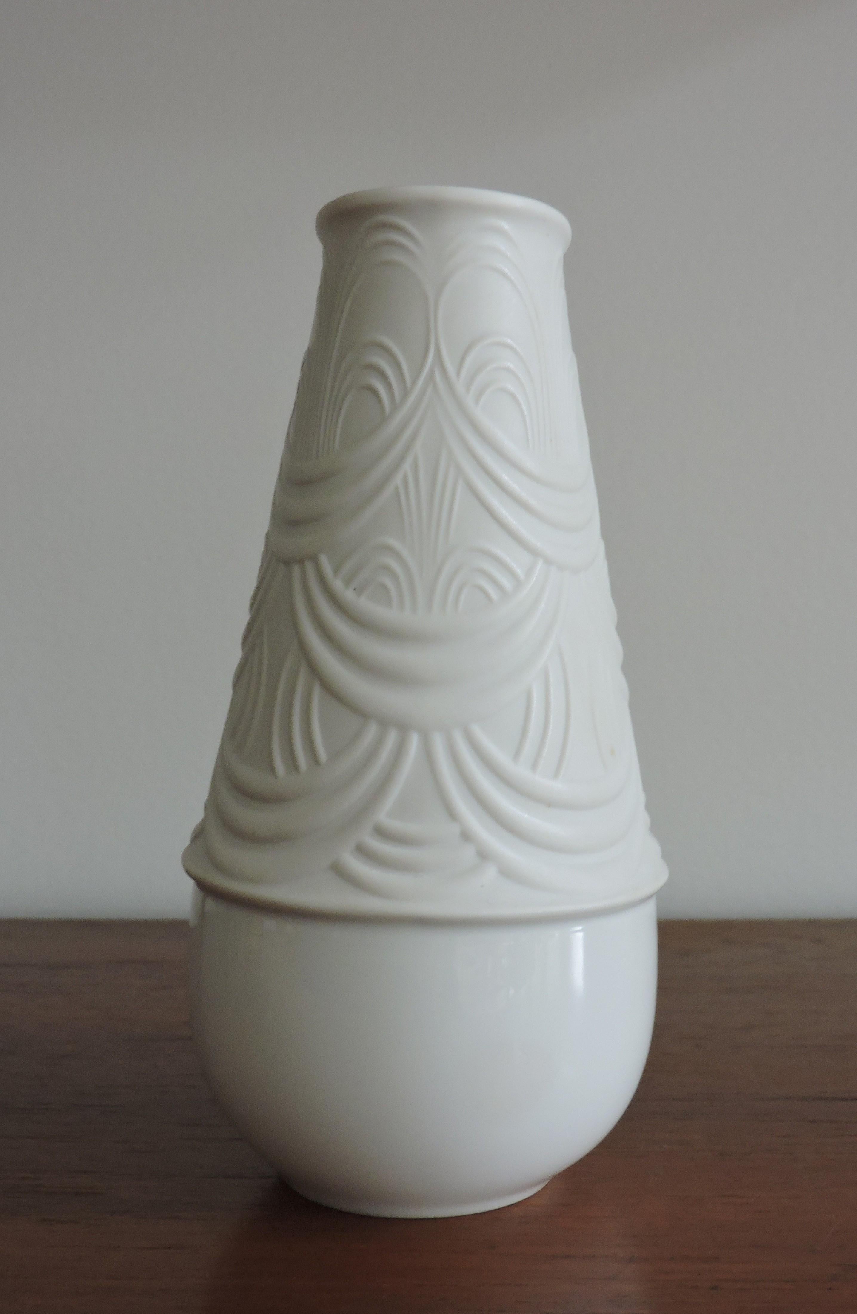 Beautiful and large 8 inch tall vase designed by Born Wiinblad for Rosenthal and manufactured in Germany. This white porcelain vase has an intricate sculptural pattern in a matte finish on the top with a gloss finish on the bottom.