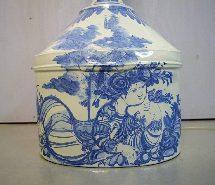 Bjørn Wiinblad (1918-2006), Dänemark. 
Einzigartige kolossale Stehlampe aus blau glasierter Keramik, verziert mit einer jungen Frau in der Nature und floralen Ornamenten. 
Original gelber Bildschirm. Datiert 1973.
Maße: 145 x 50 cm (inkl.