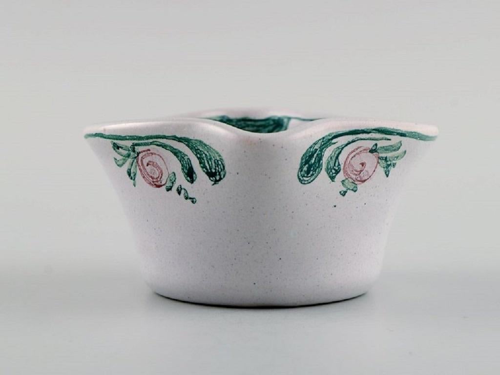 Bjørn Wiinblad (1918-2006), Denmark. 
Heart-shaped bowl in glazed ceramics with hand-painted flowers. Dated 1985.
Measures: 10 x 5 cm.
In excellent condition.
Signed and dated.
