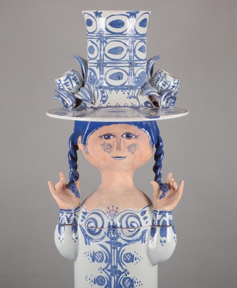 Bjørn Wiinblad (1918-2006), In our own workshop. 
Una scultura colossale di una ragazza in ceramica dipinta a mano. In quattro parti.
Scultura con trecce e un grande cappello progettato per contenere una pianta.
Firmato Bjørn Wiinblad 1960.
In