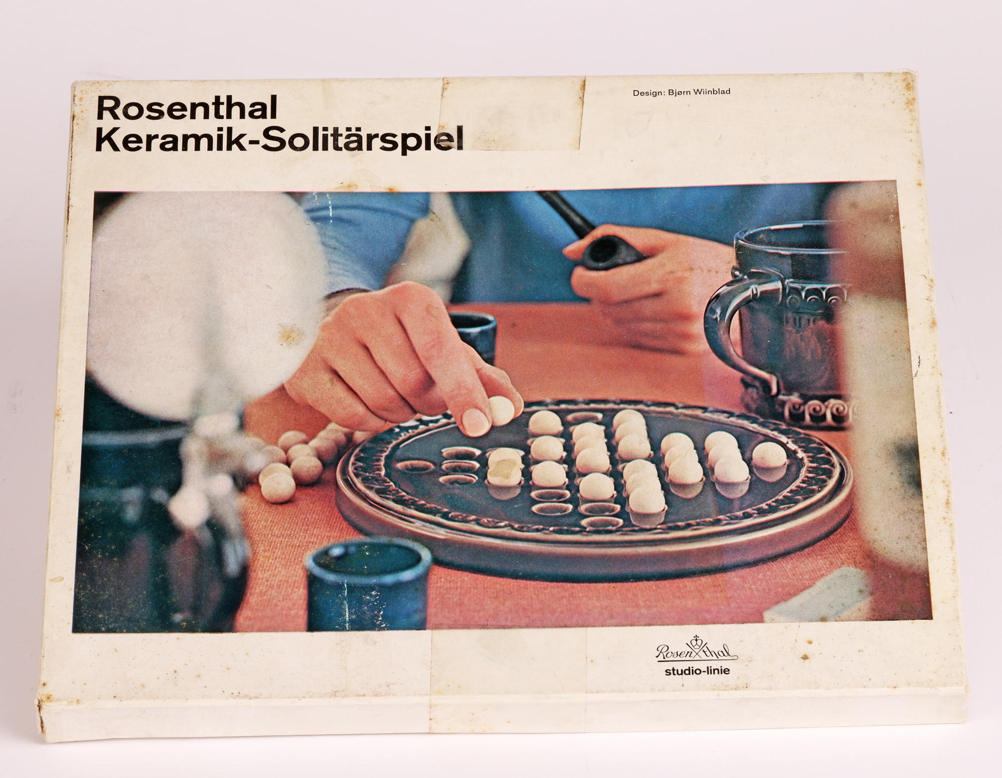 Une élégante boîte d'origine allemande Rosenthal Studio-Linie vintage 'Keramik-Solitärspiel' (jeu de solitaire) par le célèbre peintre, designer et artiste danois Bjørn Wiinblad (danois, 1918-2006) et datant d'environ 1979.

Né à Copenhague, Bjorn