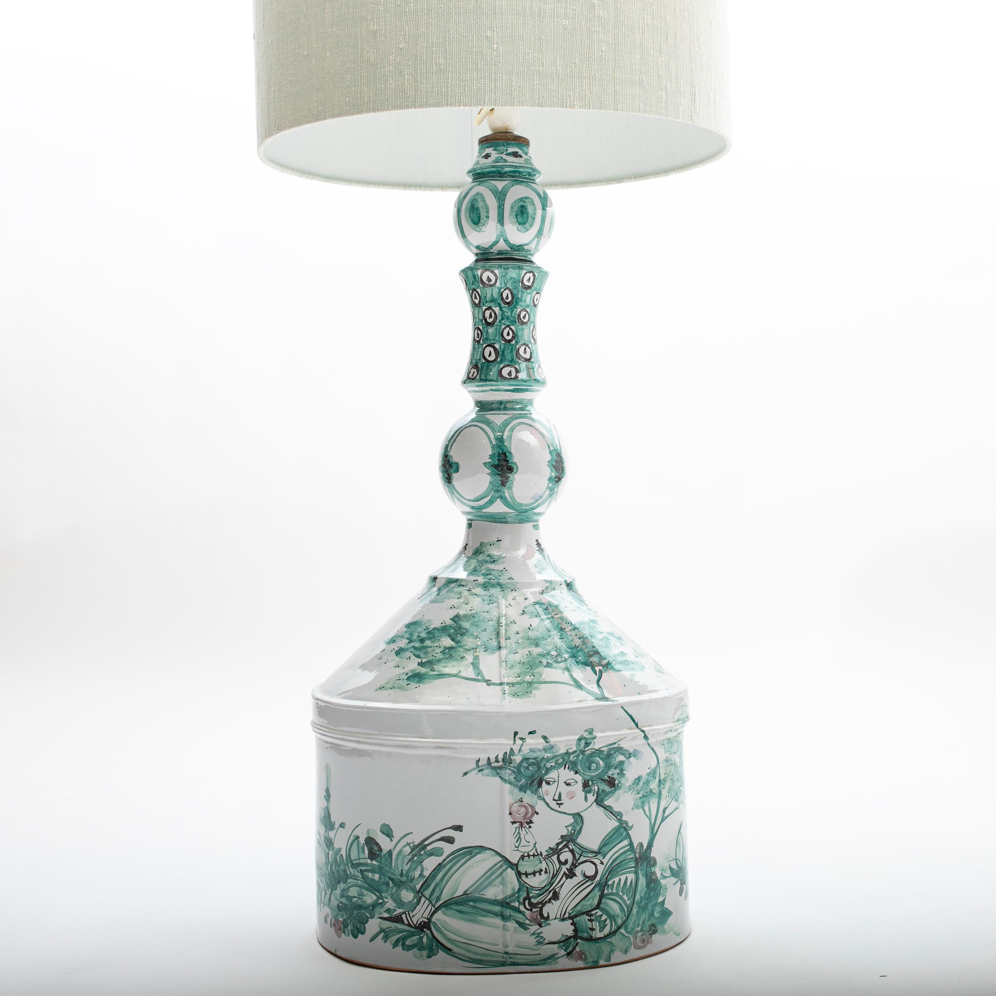 Bjørn Wiinblad 1918-2006
A large floor or table lamp in white-glazed ceramics. ( one of a kind )
Hand decorated with a young woman in nature and floral ornamentation in green, pink and black colors.

Signed and dated Bjørn Wiinblad '72.
