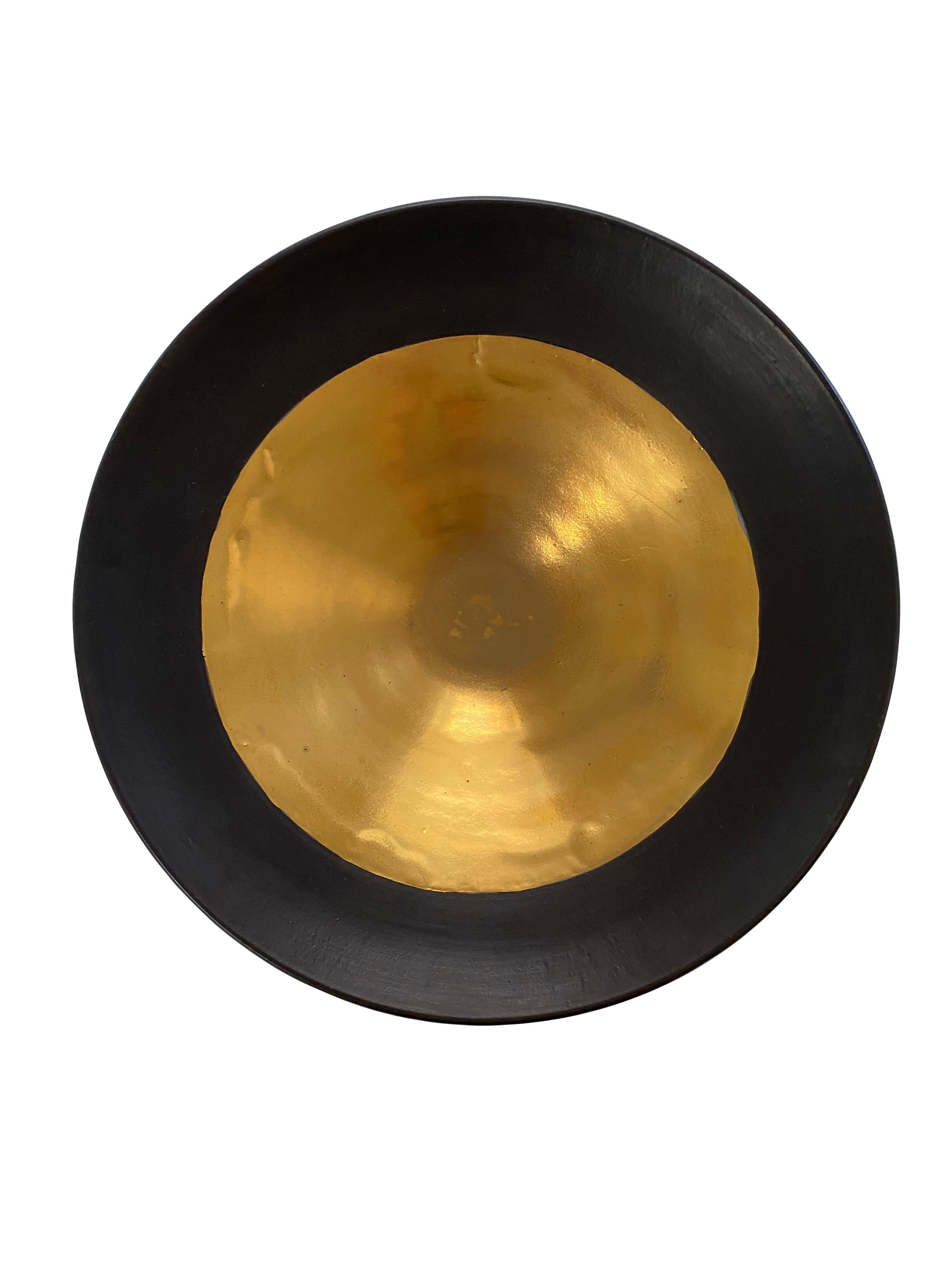 Matte black stoneware bowl with 22-karat gold interior.
Can hold water
One of several pieces from a large collection
Veteran photographer Sandi Fellman's ceramic vessels are an exploration of a new medium. The forms, palettes, and sensuality of her