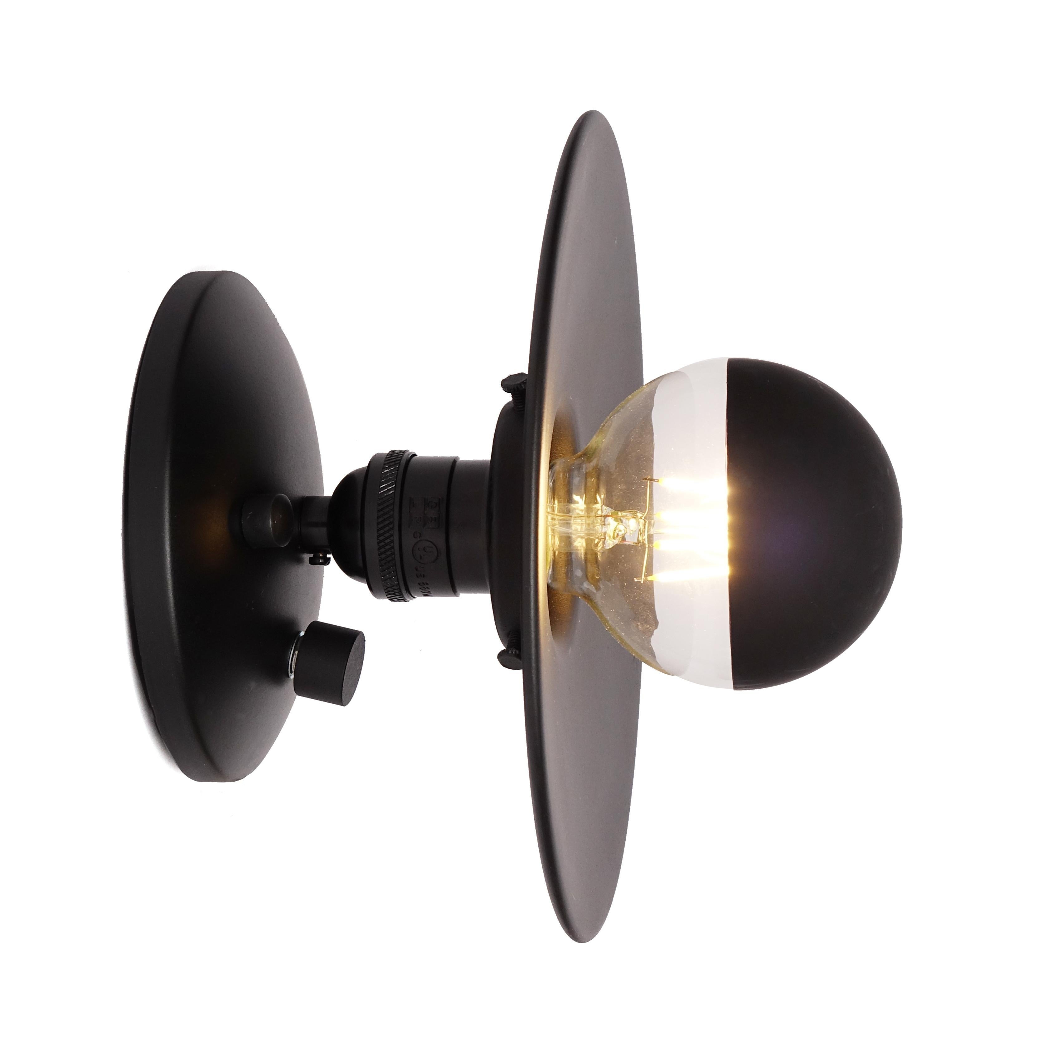 A simple modern sconce to accent your bedroom, bathroom, or work space. This contemporary light also works well in a commercial setting restaurant, retail, or office space. 
Designed by Michele Varian
Matte black metal
Overall product dimensions: