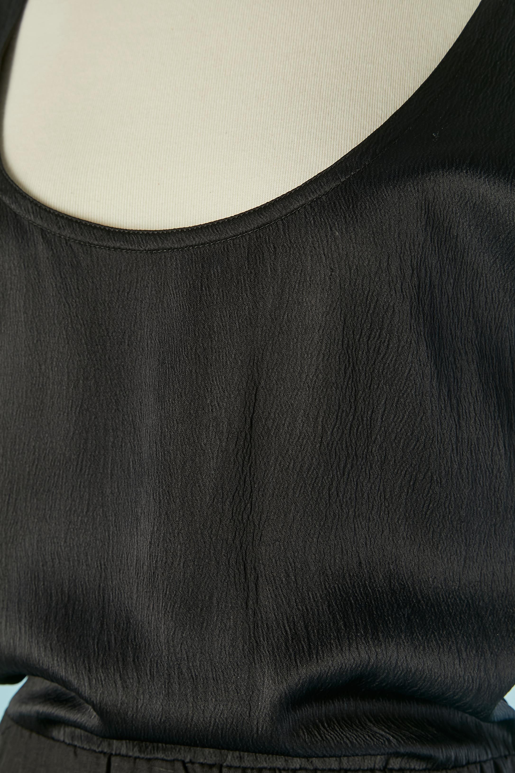 Robe noire en acétate et lin avec une longue traîne sur le devant et le dos. Composition du tissu supérieur : 80% acétate, 20% soie. Composition du tissu du bas : 100% lin 
Fermeture à glissière sur le côté gauche.
Longueur totale sous la couche=