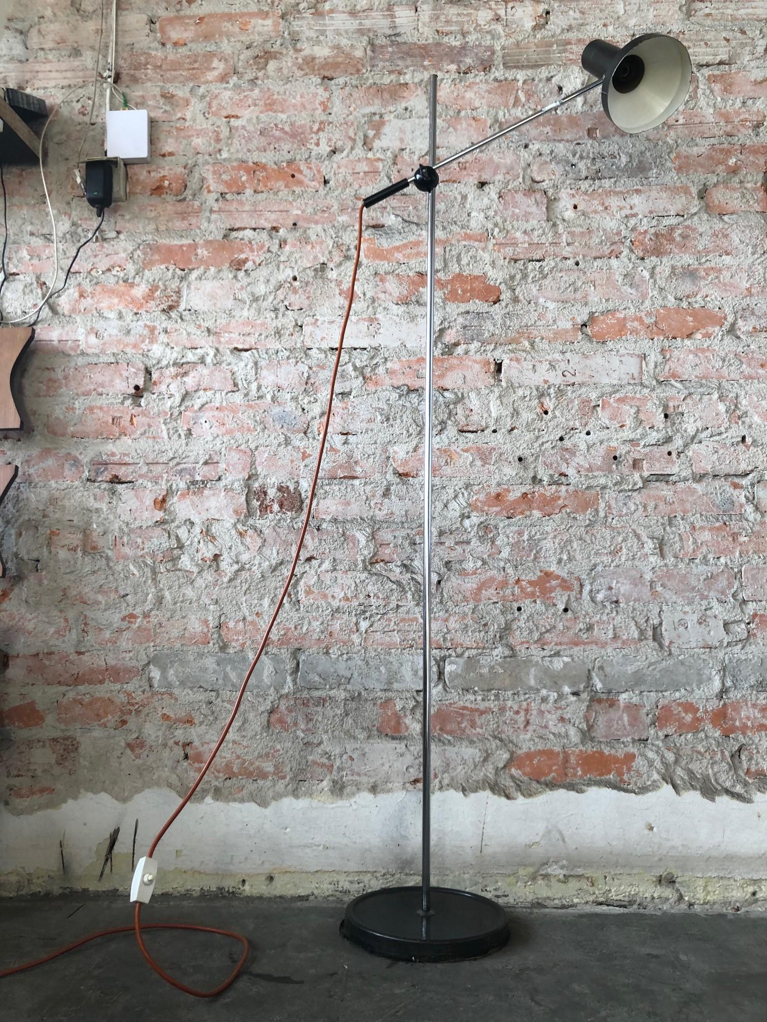 This floor lamp with adjustable height and angle was made during the 1960s. It is made of metal with black lacquer and chrome. The piece is fully functional and is in a good vintage condition.