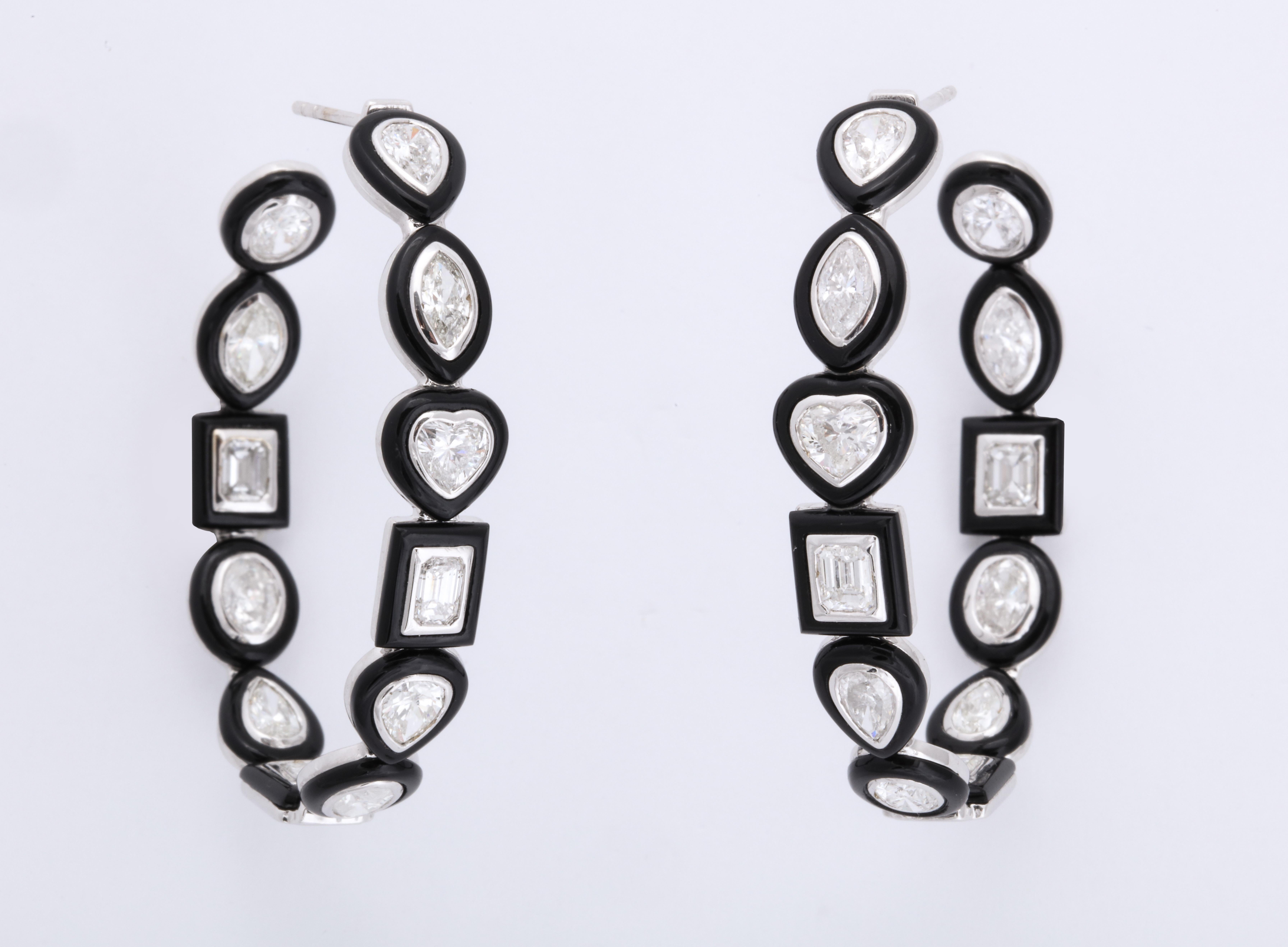 Extraordinary hoop earrings featuring oval, marquise, emerald cut, pear and heart shape diamonds each individually encircled in custom cut black agate.  The great contrast between the black and white lends an Art Deco feel to the design, while the