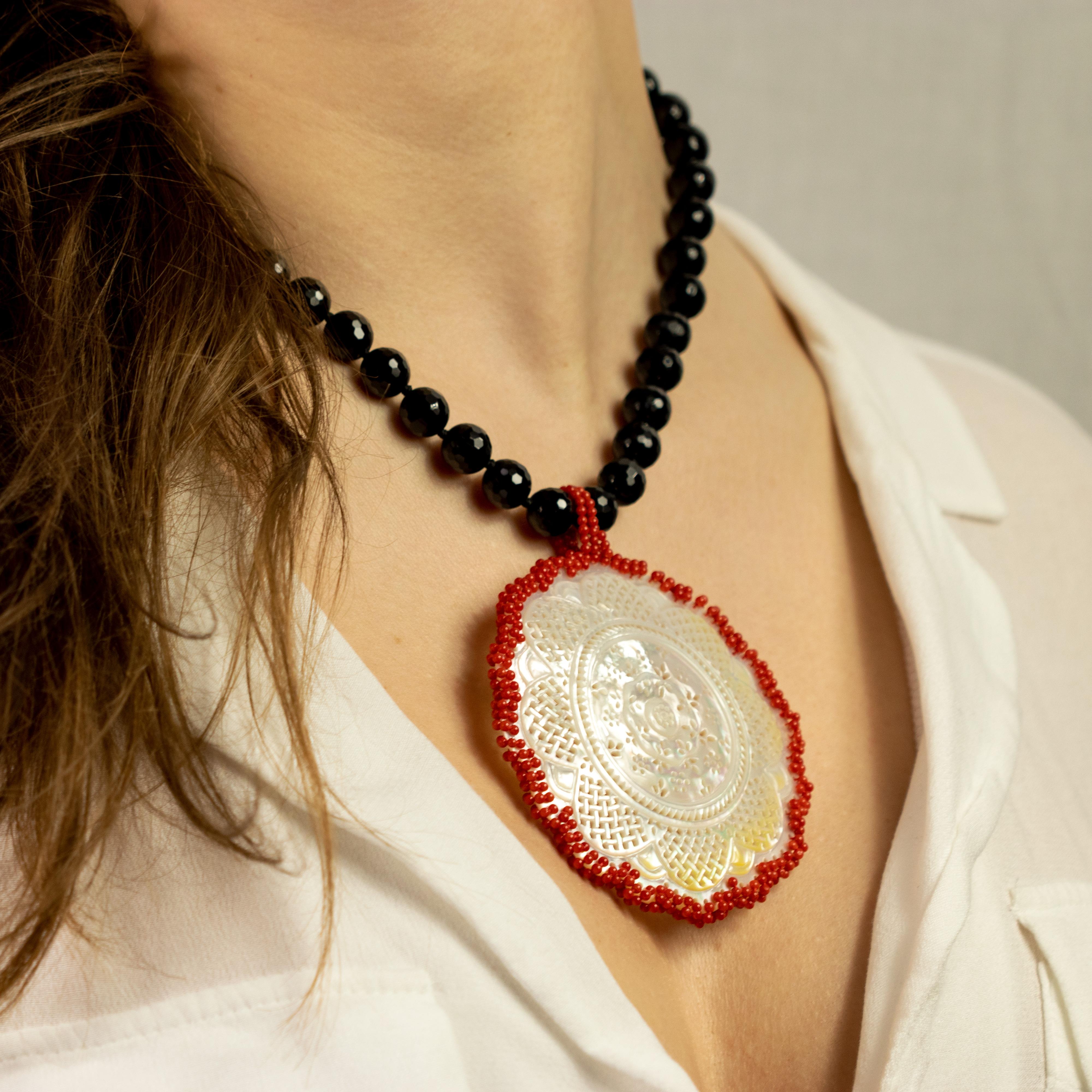 Artistic piece in faceted black agate with a central mother of pearl medallion outlined by a red coral frame.

In the ancient Asian story says that there were a couple of lovers, so in love that they used to build mother of pearl medallions and hid
