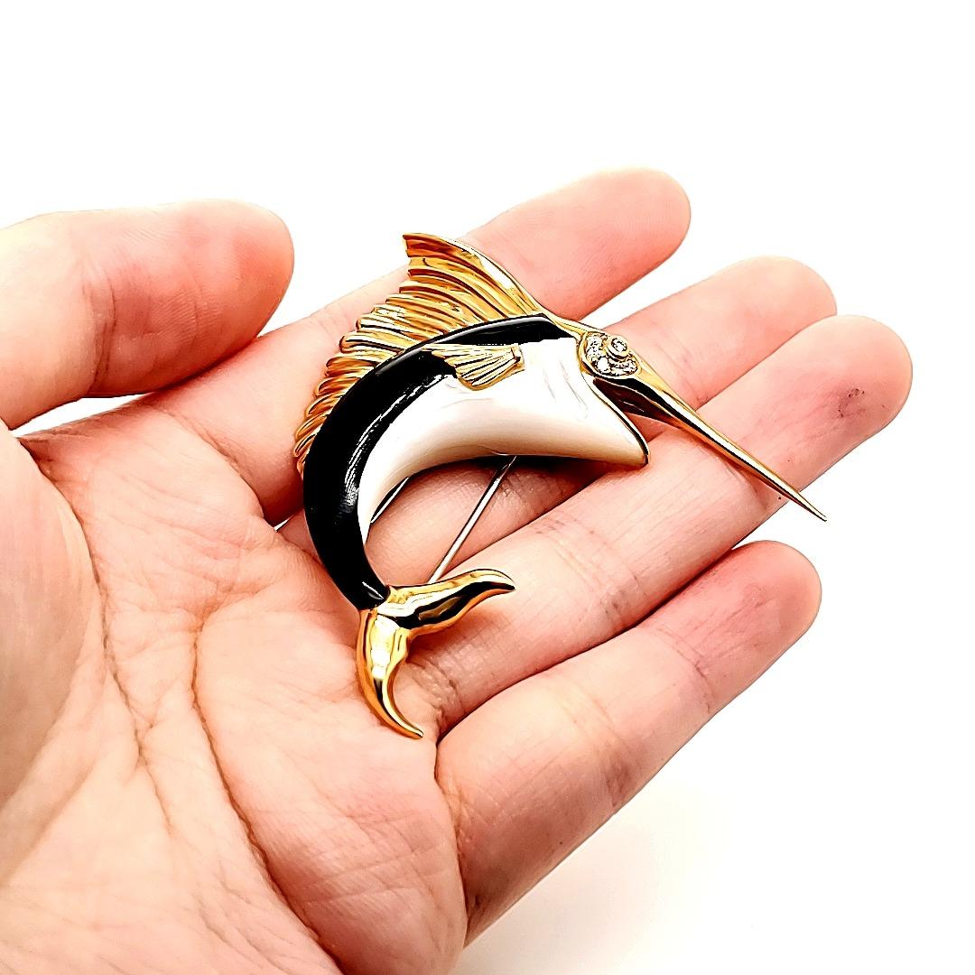 Black Agate, Mother of Pearl, Swordfish pin crafted in 18 K gold. 

Ever have that need to be seen and talked to more often? This is your chance to be seen and noticed always. Also to make new friends as people walk up to you just to talk to you,