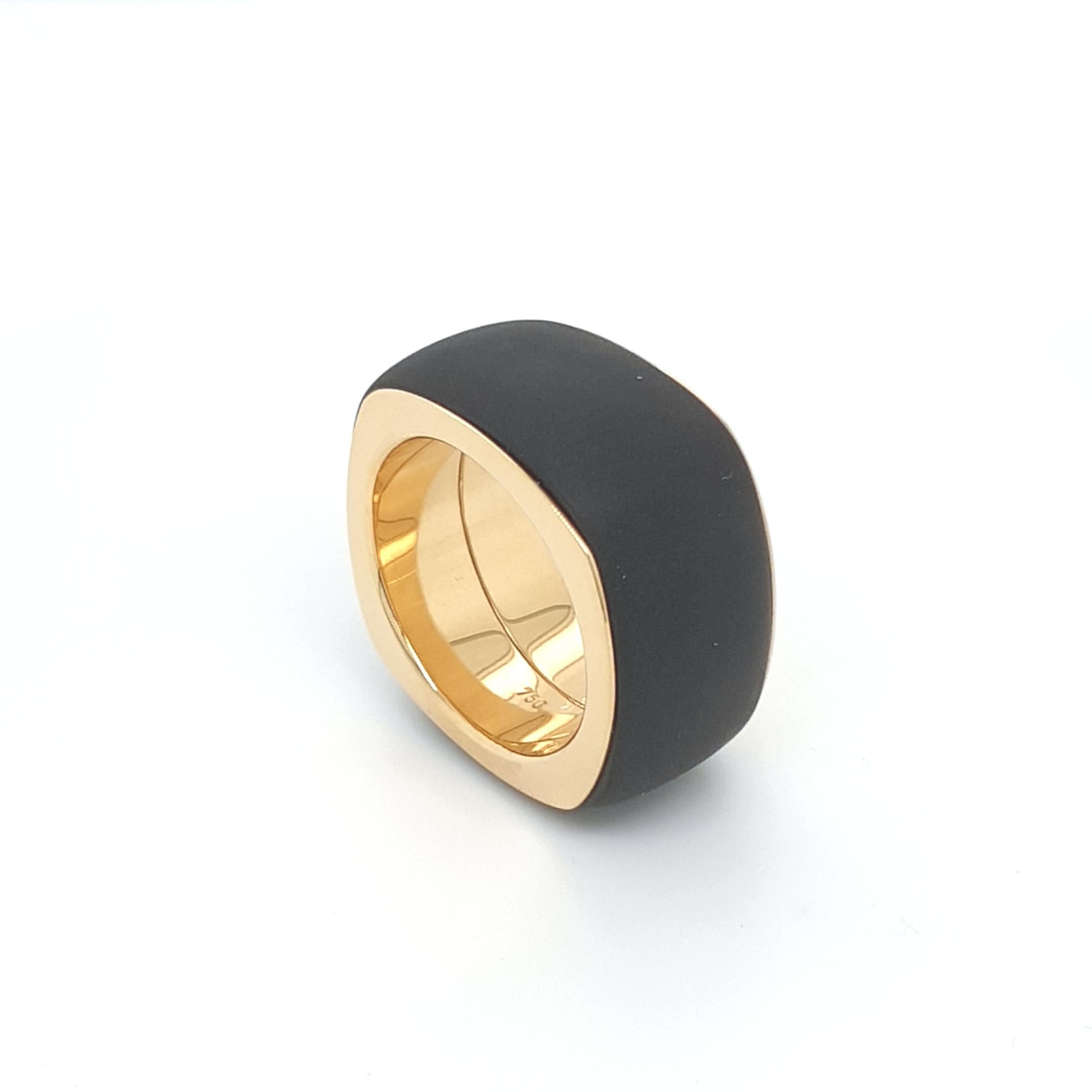 Cette bague en agate noire et onyx avec or jaune 18 carats est entièrement réalisée à la main et taillée d'une seule pièce.
La découpe ainsi que l'orfèvrerie sont réalisées en qualité allemande.
La forme en coussin de l'onyx semi-poli, combinée à
