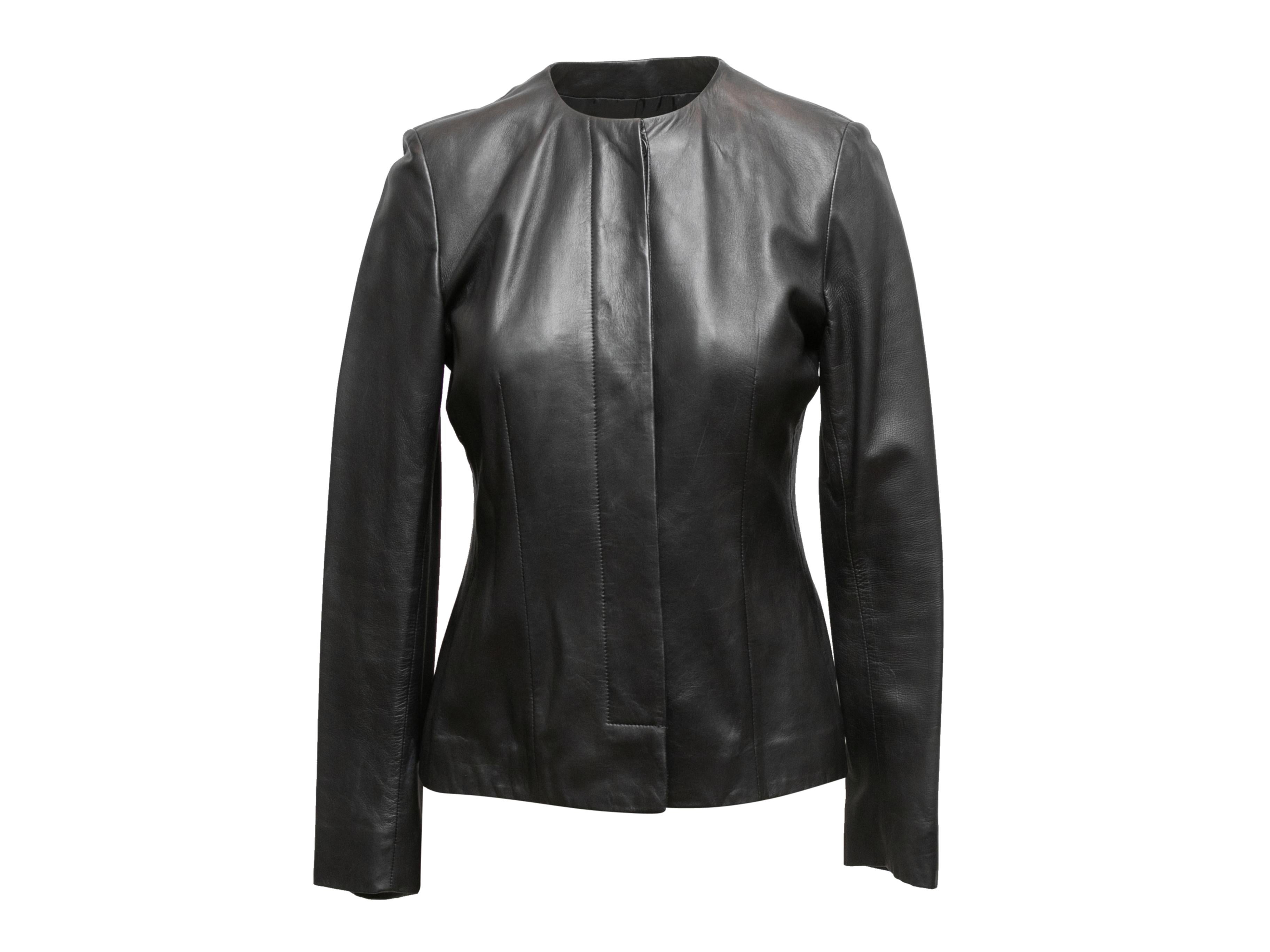 Black collarless leather jacket by Agnona. Crew neck. Concealed front button closures. 31