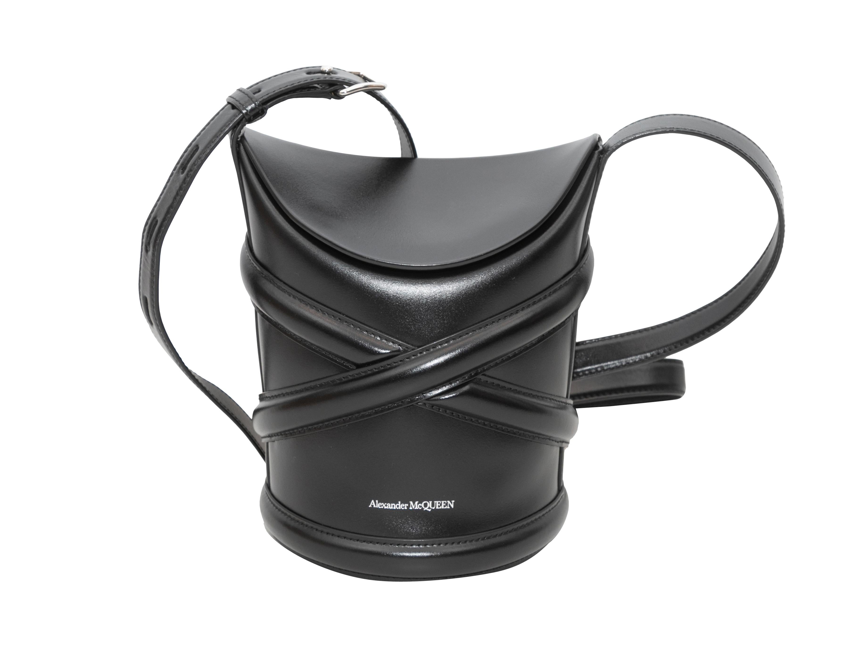 Product Details: Black Alexander McQueen Leather Bucket Bag. This bucket bag features a leather body, silver-tone hardware, a single adjustable shoulder strap, and a top flap closure. 7
