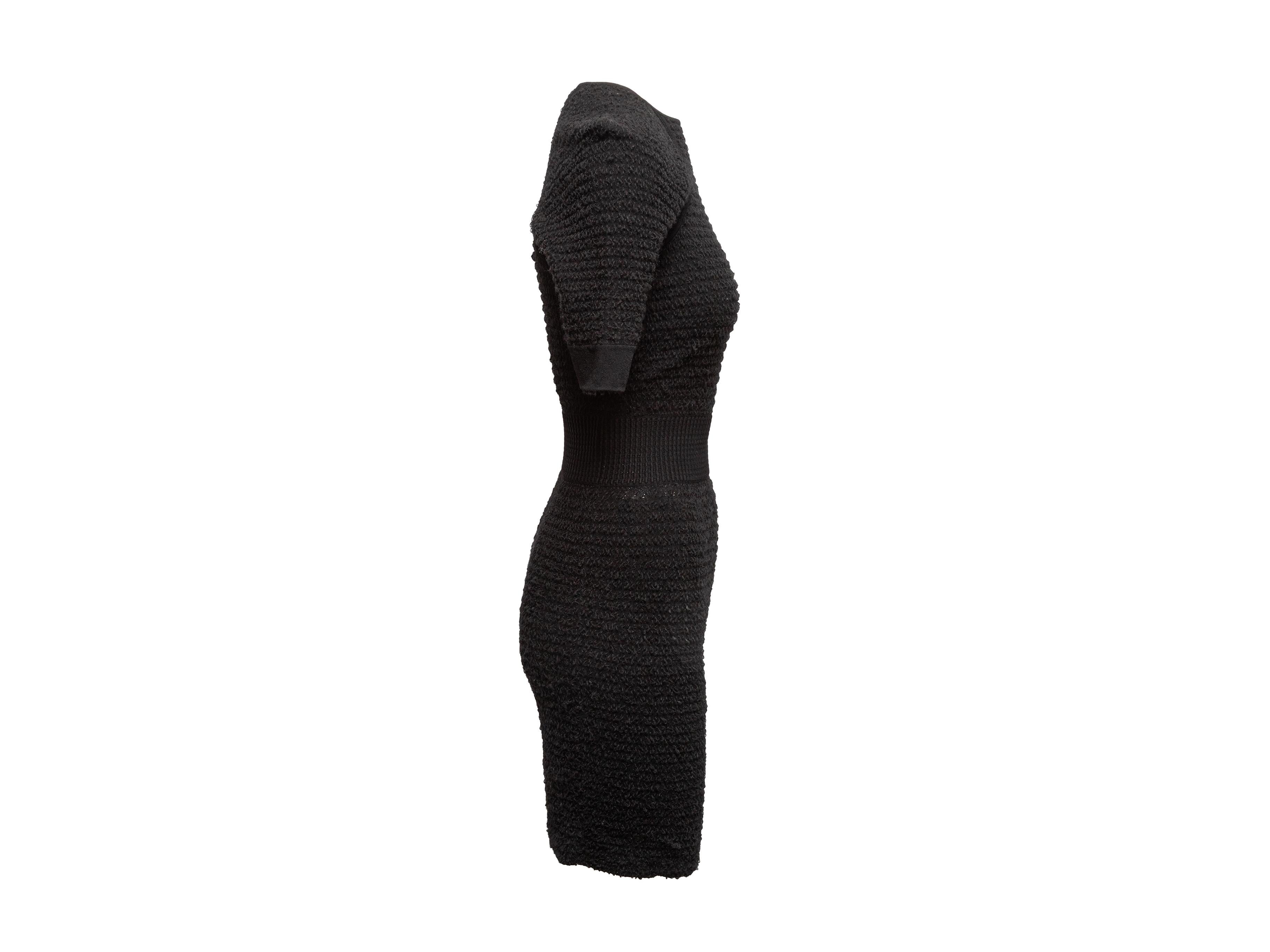 Black textured knit dress by Alexander McQueen. Crew neck. Short sleeves. 28