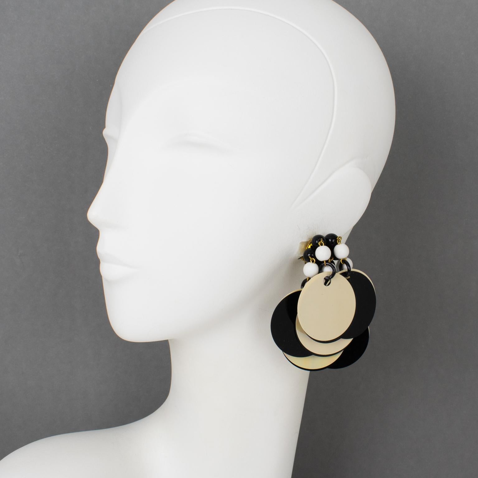 These superb dangling clip-on earrings were crafted in the 1960s in Italy. They feature a dangle drop design built with oversized rhodoid sequin disks in black and Aurora Borealis AB colors. The gilded metal hardware is embellished with black and
