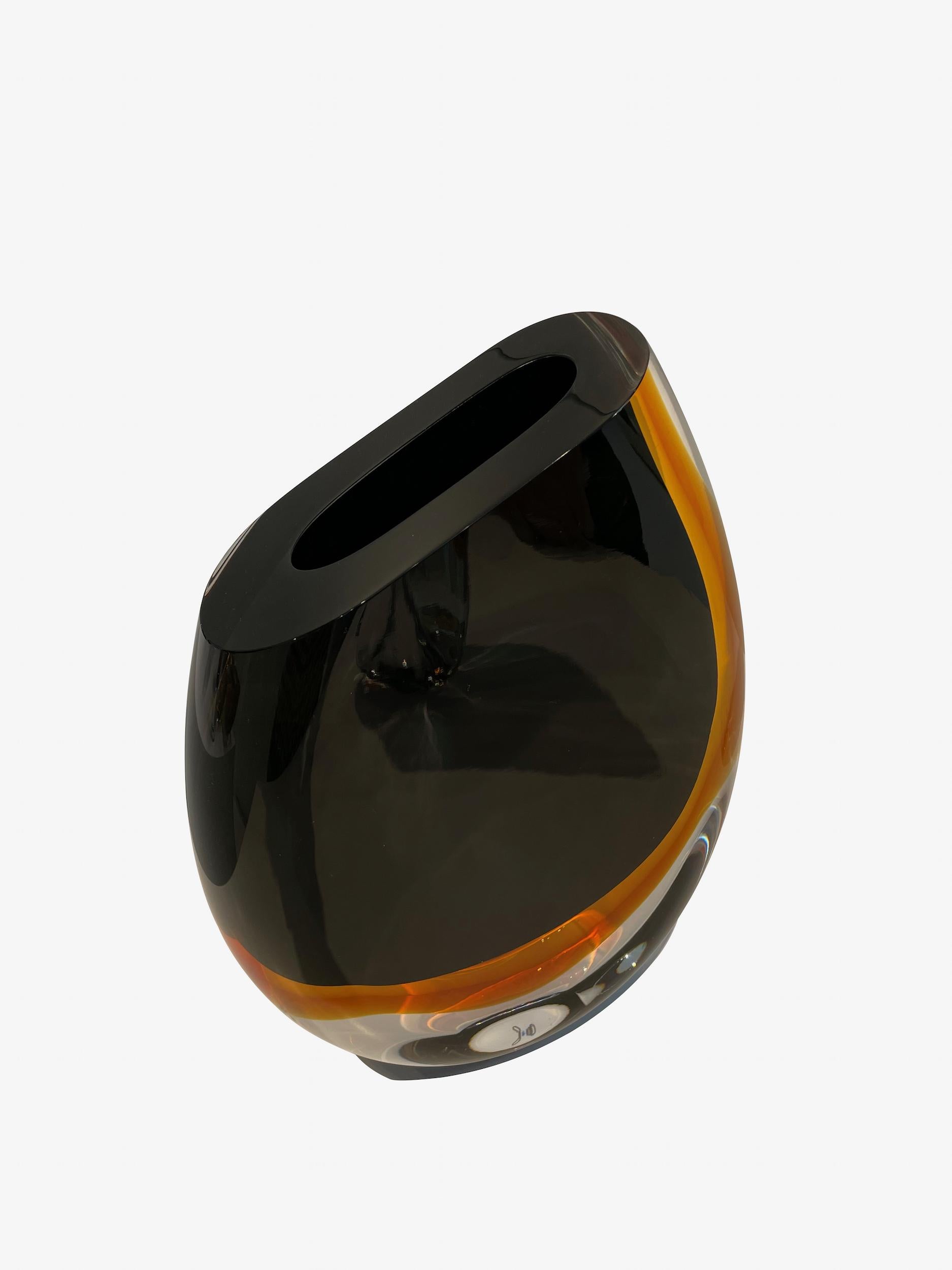 Contemporary Brazilian thick glass vase with rounded base and slanted opening.
Black glass with amber colored accents.
Sits nicely with shorter (S6998) and taller (S6999 ) vases.